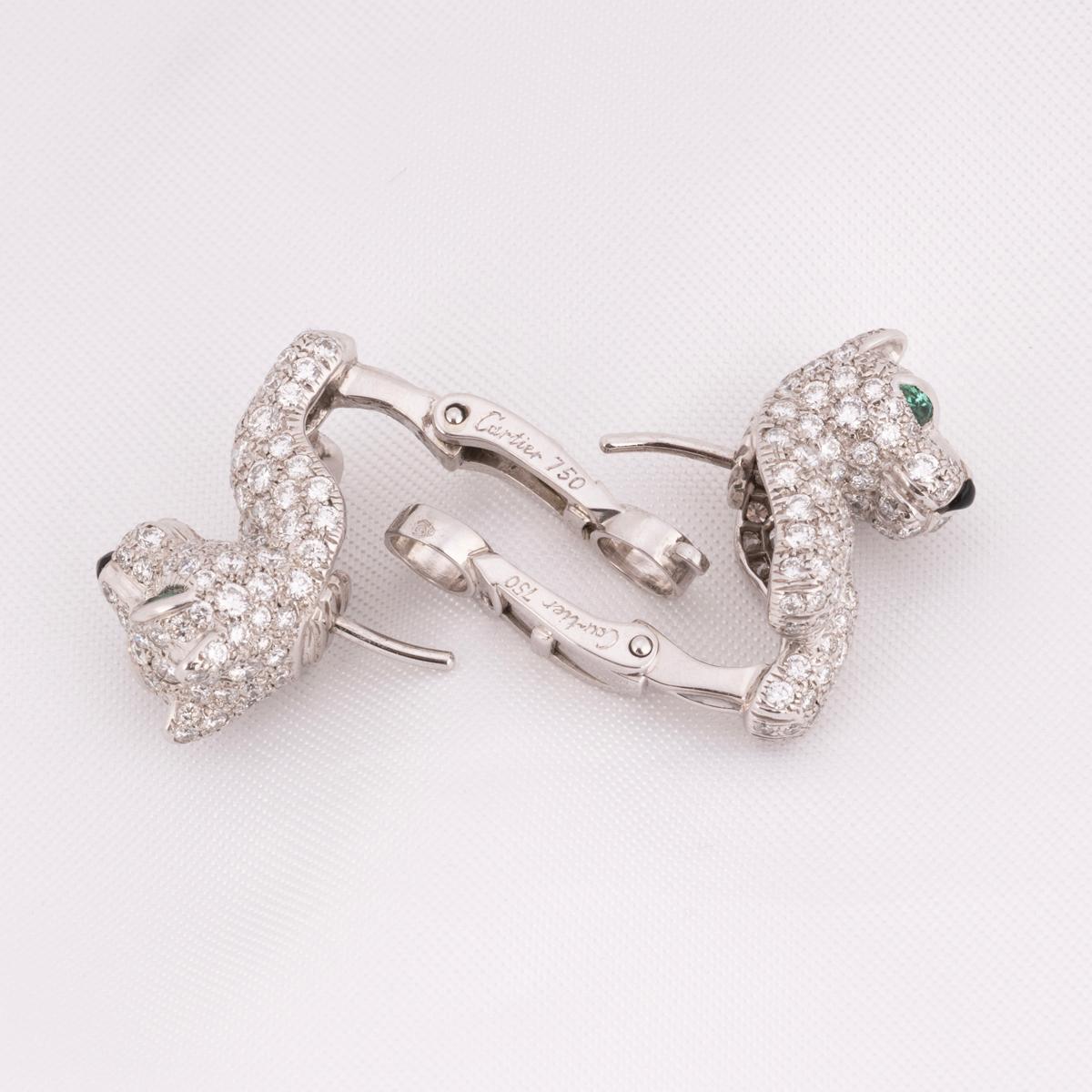 Un paio di orecchini Cartier in oro bianco 18 carati con diamanti, smeraldi e onice della collezione Panthere De Cartier. Gli orecchini presentano una testa di pantera  e griffe incastonate con circa 240 diamanti rotondi taglio brillante per un peso