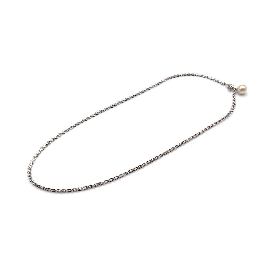 Authentic Cartier necklace crafted in 18 karat white gold is comprised of circle links. The necklace closure features a pearl and a single round brilliant cut diamond with an estimated carat weight of 0.15. The round pearl has a a white body color