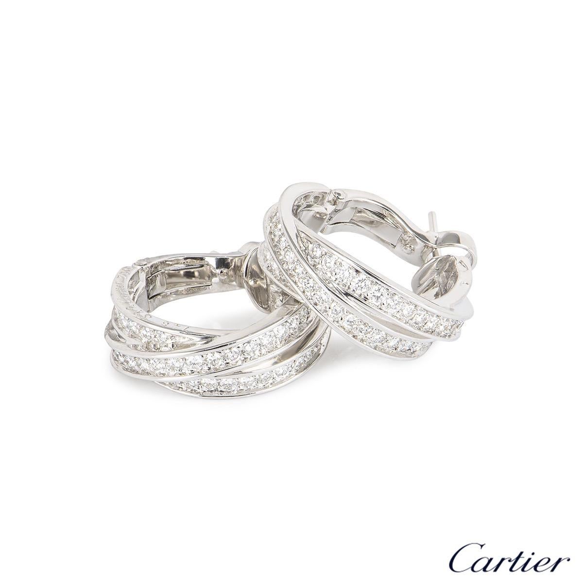 A sparkly pair of 18k white gold Cartier diamond hoop earrings from the Trinity de Cartier collection. The earrings comprise of 3 intertwined white gold bands with round brilliant cut diamonds pave set throughout. The diamonds have a total weight of