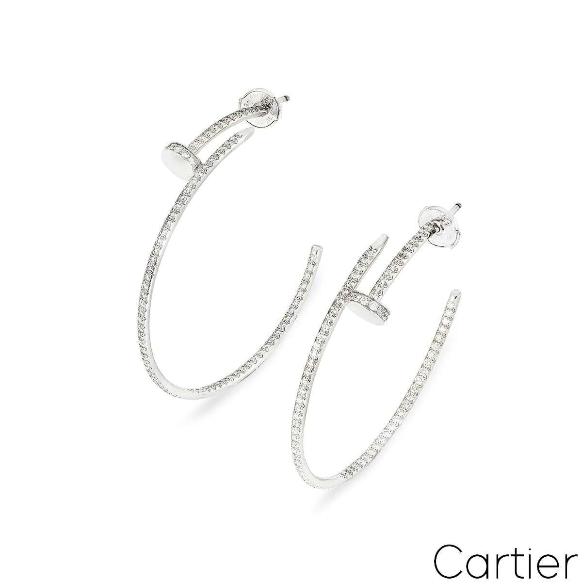 A stunning large pair of white gold diamond encrusted Cartier earrings from the Juste Un Clou collection. The earrings are wrapped around with a nail head at one end and nail end at the other tip, each set with approximately 176 round brilliant cut