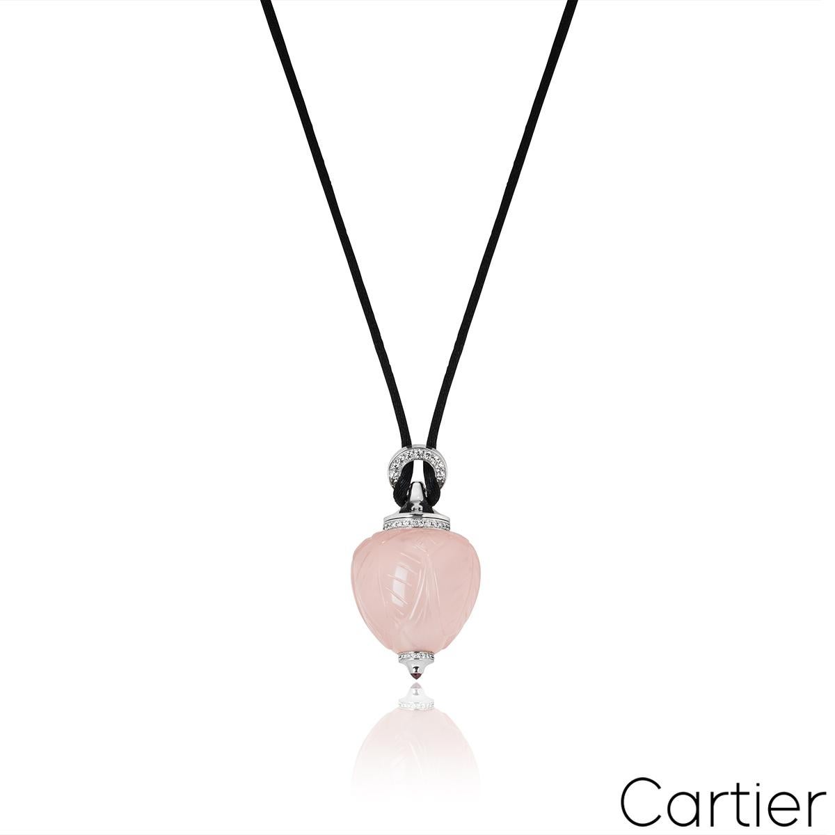 A rare 18k white gold Cartier perfume bottle pendant from the Inde Mystérieuse collection. The body of the pendant features rose quartz with carved leaf motifs throughout. Further complementing the intricate design are 62 round brilliant cut