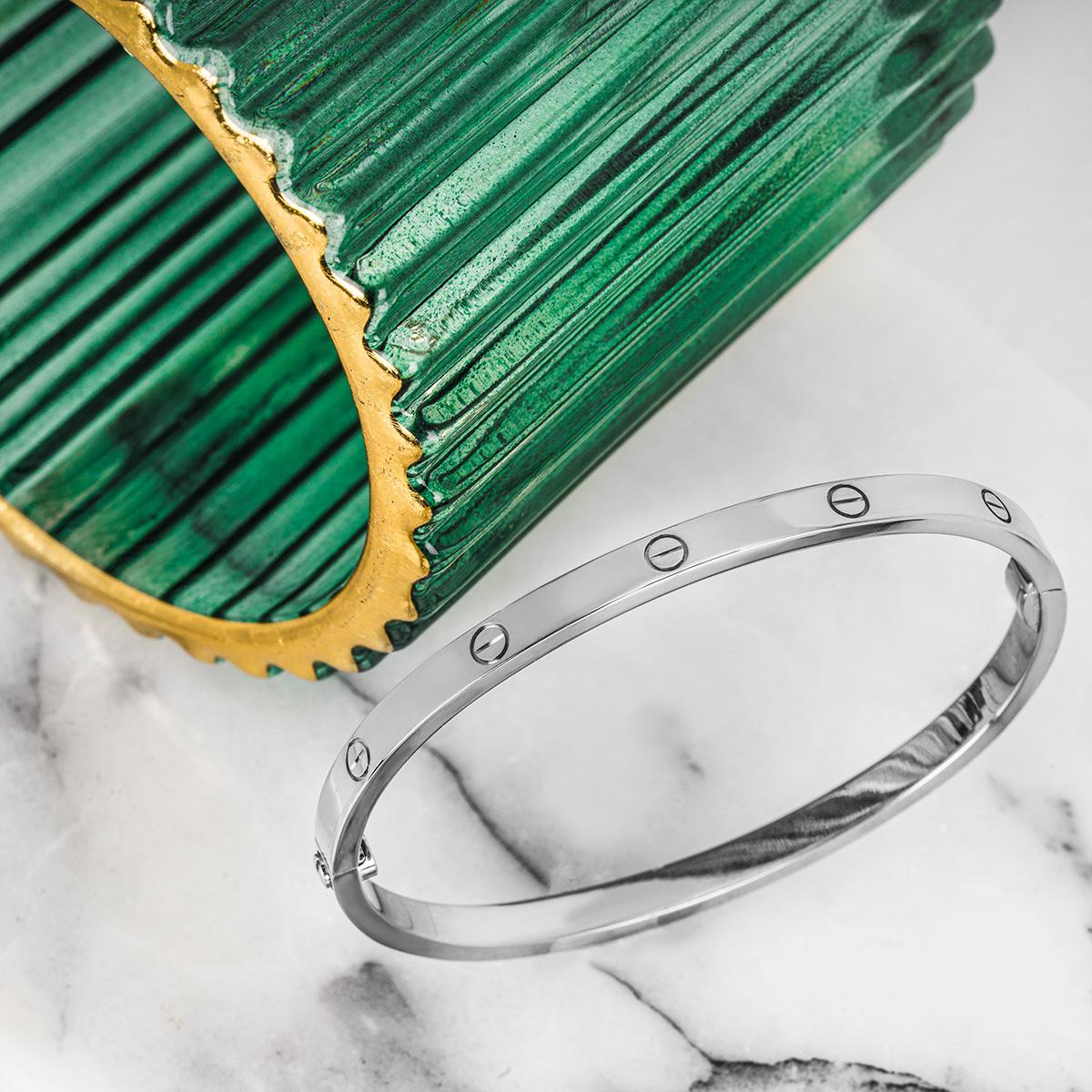 A 18k white gold Cartier bracelet from the Love collection. This slimmer version of the classic Love bracelet features Cartier's iconic screw motifs and a single screw and hinge fitting. The bracelet is a size 16 and has a gross weight of 18.7