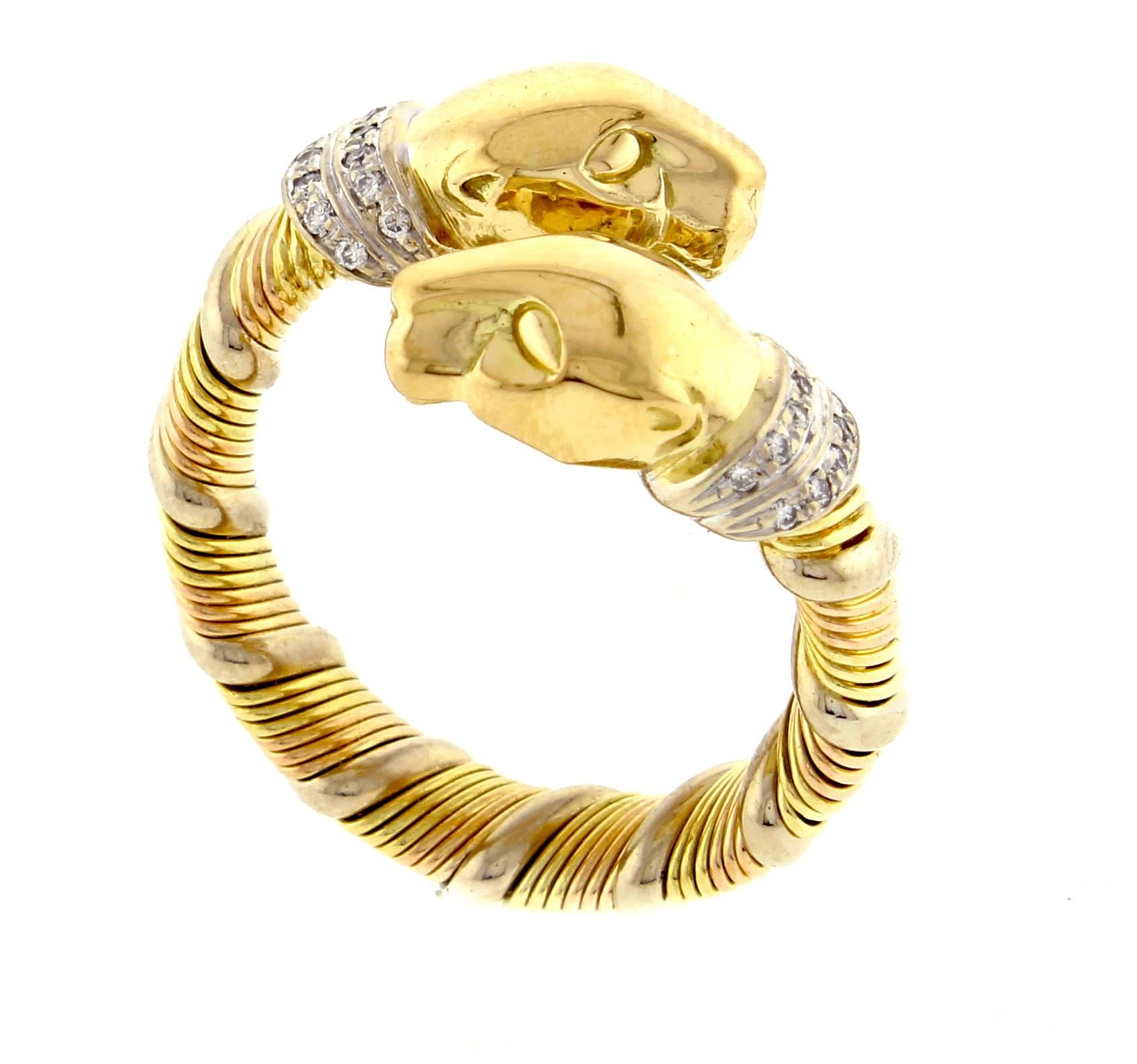 From Cartier's iconic Panthere collection, a double panther head ring Coils of white yellow and pink 18 karat gold hold to polished panther heads and a diamond collar.  size 55  US 7¼