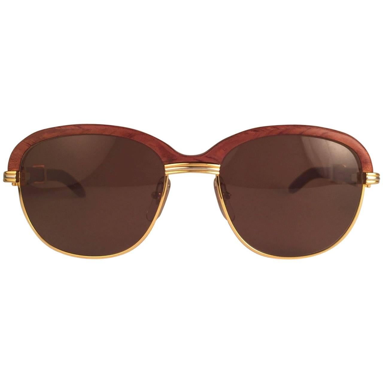 Original 1990 Cartier Malmaison hardwood sunglasses with honey brown(uv protection) lenses. 
Front and sides in yellow and white gold and has the famous wooden front. Temples are also Palisander combined with gold. 
Amazing craftsmanship! All