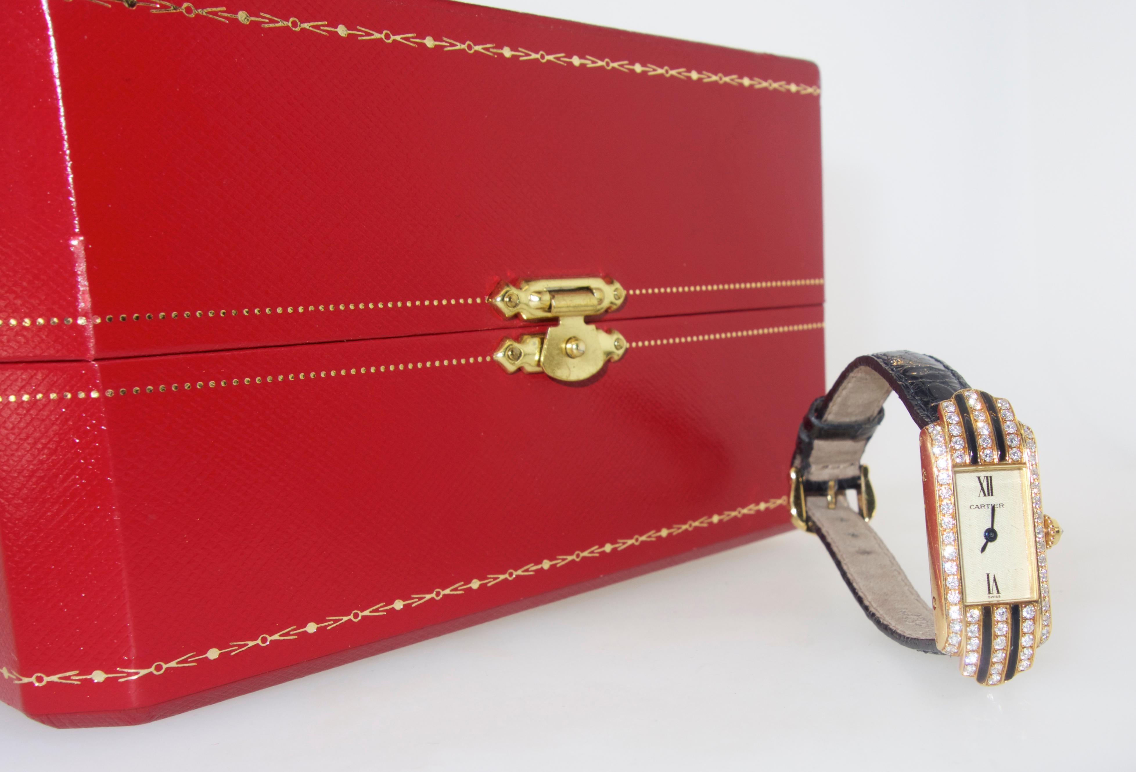 Cartier tank wristwatch with  1 ct. of fine white diamonds, (71), and black enamel.  This 18K watch has a  quartz movement.  It comes with its original box.  Signed and numbered on the verso with a new Cartier strap.