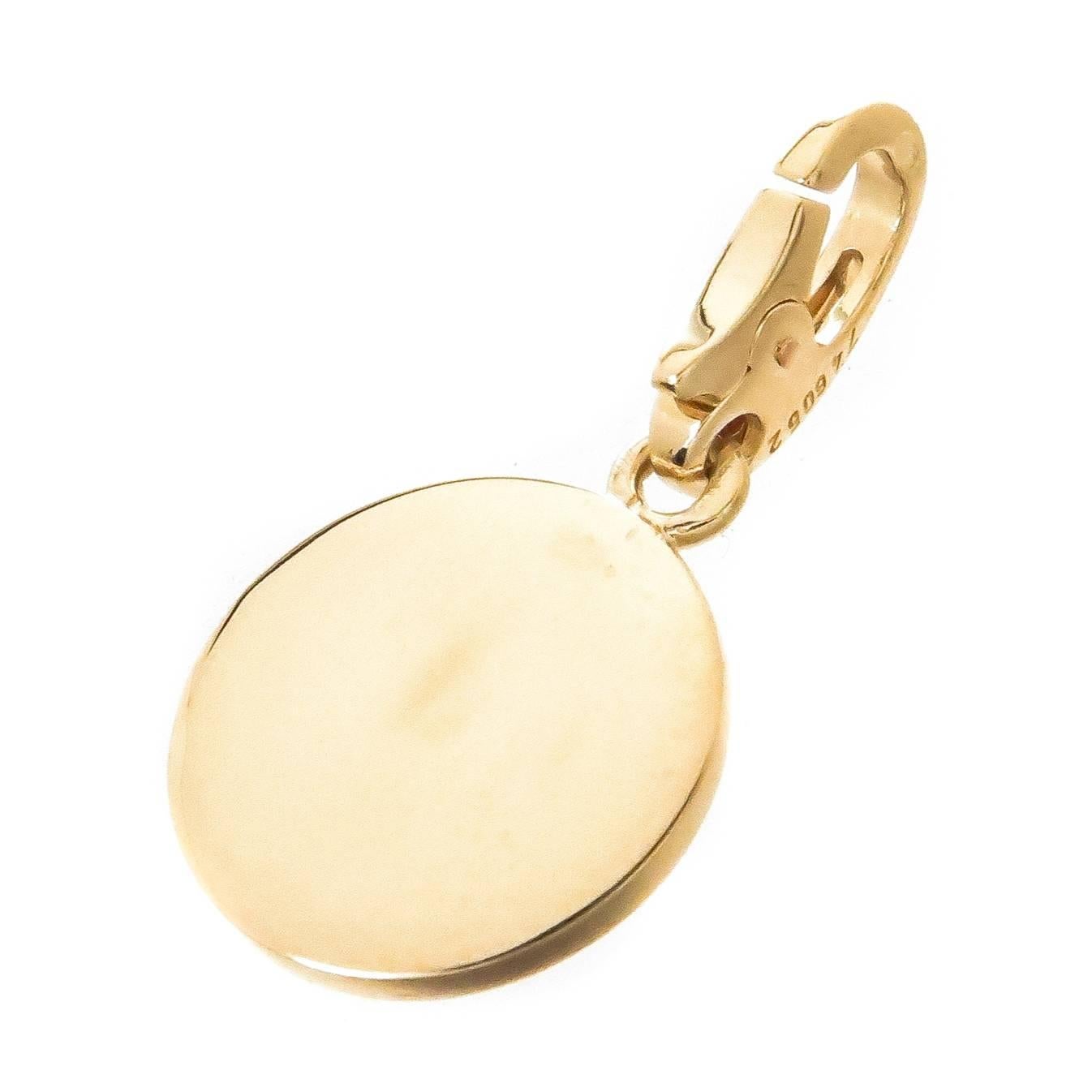 Circa 2005 Cartier 18K Yellow Gold Charm with Applied White Gold and Diamond set Cross, measuring 1/2 inch in diameter and set with Fine Round Brilliant cut Diamonds totaling .15 carat.  having a Lobster claw lock for easy take on and off to be worn