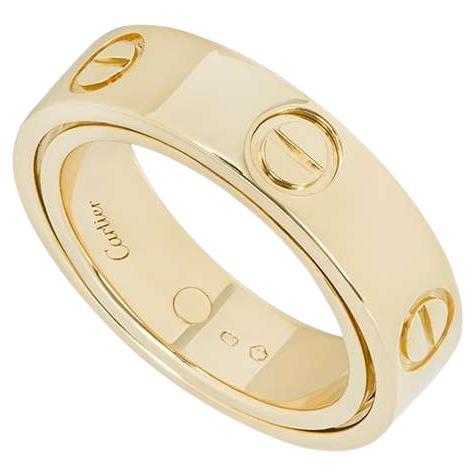 An 18k yellow gold Love ring from the Cartier Astro collection. The ring holds the same design as an original love ring, featuring the 6 iconic screw motifs. This ring differs as it opens up to form a pendant made up of a ball with three