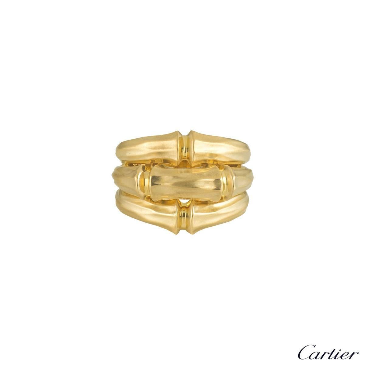 Une élégante bague Cartier en or jaune 18k de la collection Bamboo. La bague est sertie au centre de 3 motifs iconiques de bambou. La bague est dotée d'un anneau satiné et mesure 1::7 cm de haut et 0::7 cm de large. Elle correspond à la taille UK