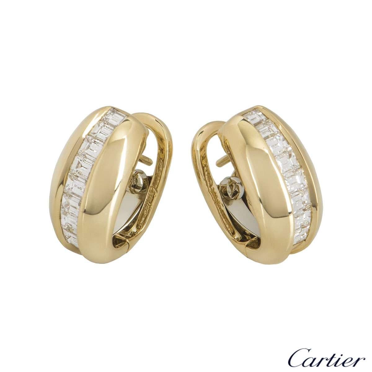 A pair of 18k yellow gold Bombe style earrings by Cartier. The earrings are each set with 8 baguette cut diamonds, totalling approximately 1.44ct. The earrings measure 1.8cm in length and feature post and hinge clip fittings, with a gross weight of