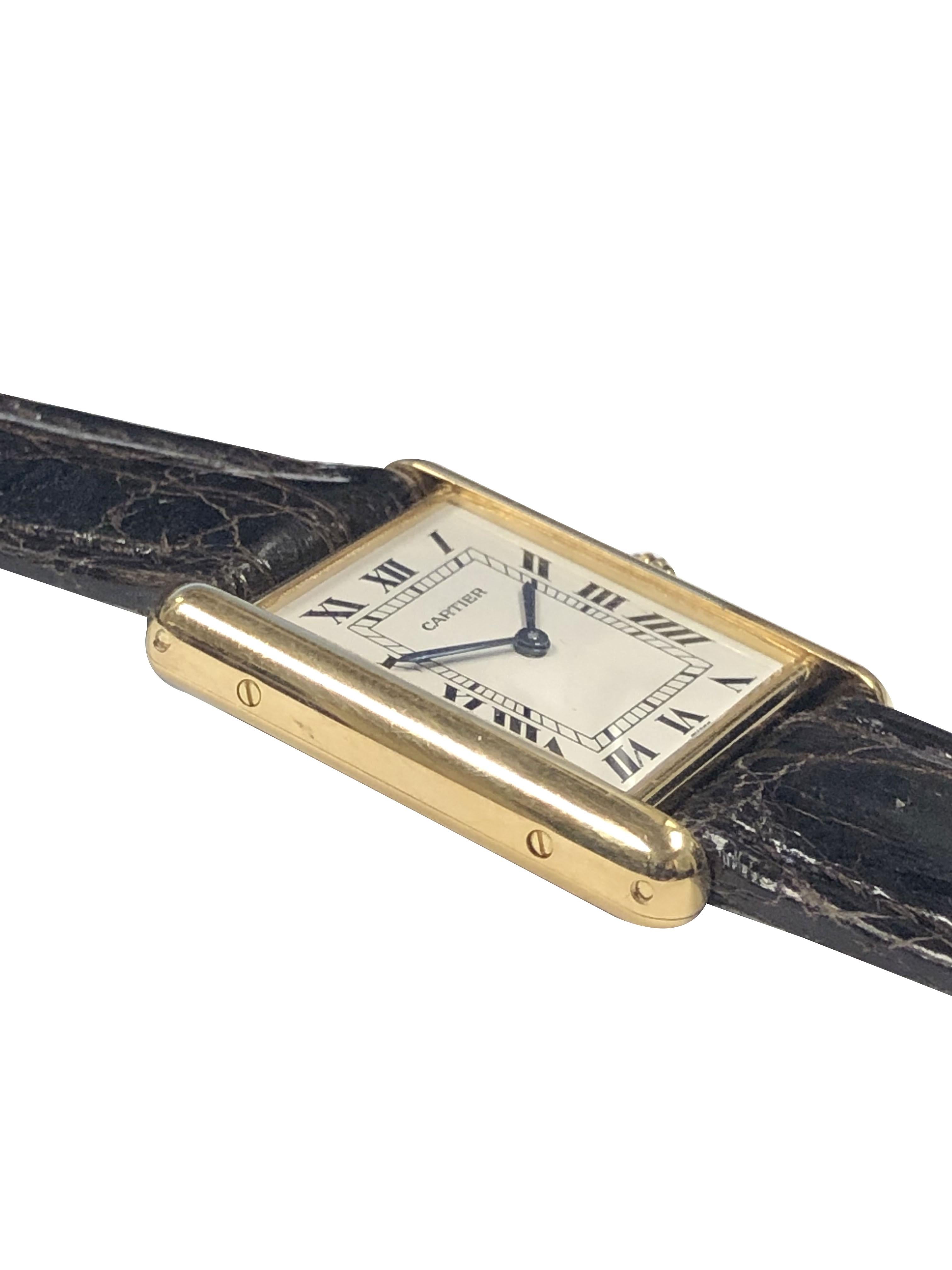 Circa 2000 Cartier Louis Cartier mid size Tank Wrist Watch, 30 X 23 M.M. 2 Piec e 18K yellow Gold case, Quartz movement, Sapphire Crown, White Dial with Black Roman numerals. New Brown Crocodile stitched strap with a Cartier Gold Plate Tang Buckle.