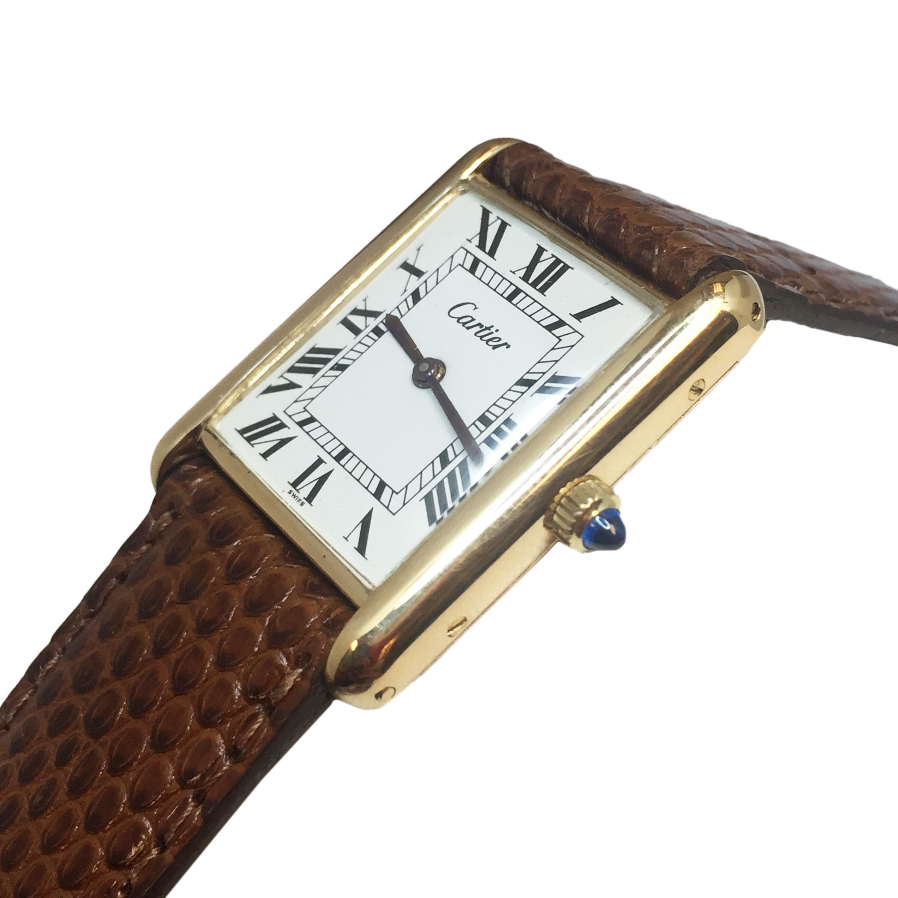 Circa 1970s Cartier Classic tank watch, 30 X 24 MM 2 piece 18K yellow gold case, mechanical, manual wind 17 Jewel Cartier movement, White dial with Black Roman Numerals, sapphire Crown. New Cartier Brown Lizard strap with Gold Plate Tang Buckle.