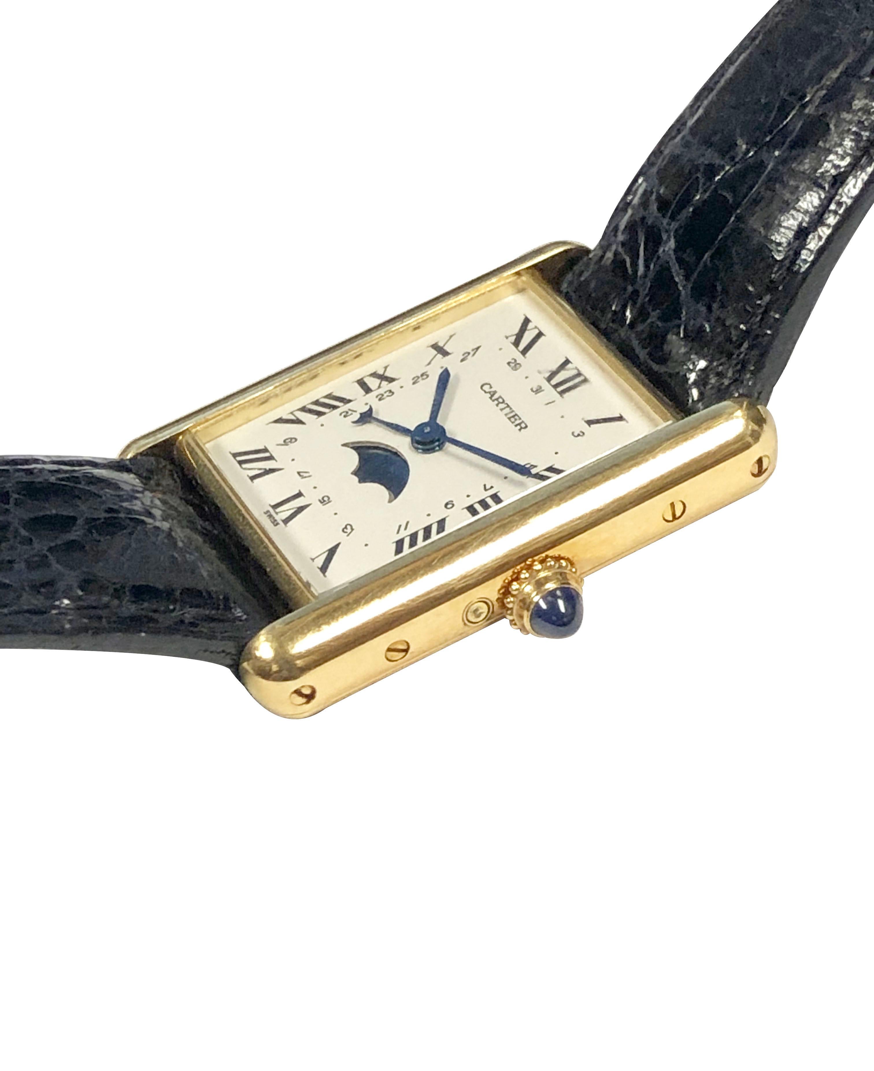 Circa 2000 Cartier Classic Tank Wrist Watch, 30 X 23 M.M. 18K Yellow Gold 2 piece case. Sapphire Crown, Quartz movement, MoonPhase window at the 6 position and inner Calendar track.  Original Cartier Black Crocodile Strap with Cartier Gold Plate