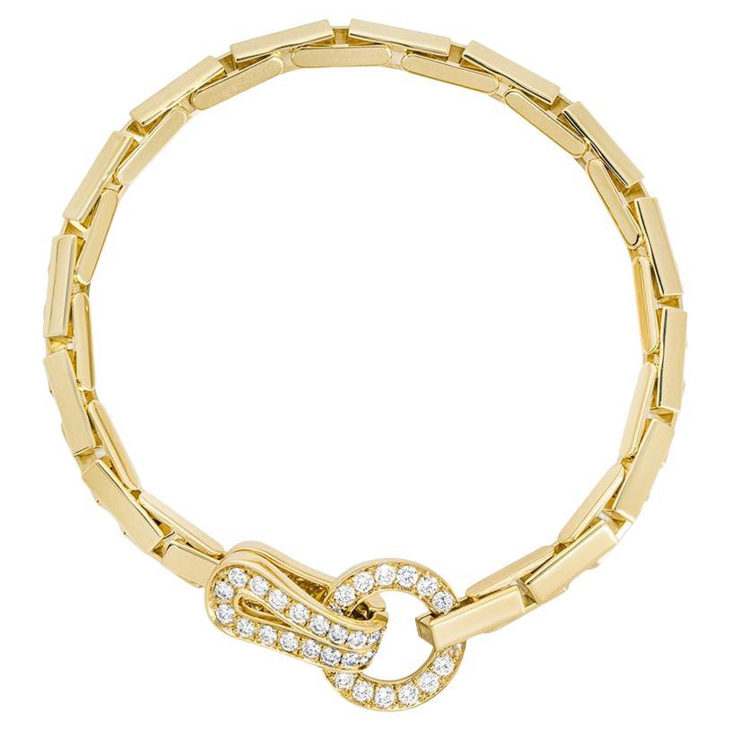 An 18k yellow gold bracelet by Cartier from the Agrafe collection. The bracelet features the classic openwork Agrafe diamond set motif connected by brick style links. There are 35 round brilliant cut diamonds with a total weight of approximately