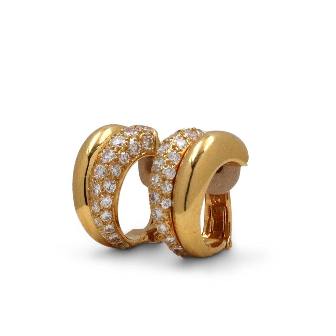 Authentic Cartier double hoop earrings crafted in 18 karat yellow gold.  One half of the split design is pave set with glittering round brilliant cut diamonds of approximately 1.10 total carat weight.  The other half is smooth, high polished gold