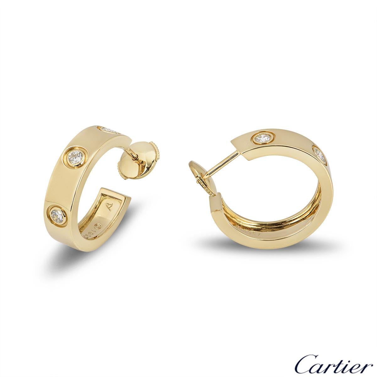 A pair of 18k yellow gold diamond earrings from the iconic Love collection by Cartier. Each hoop earring is set with 3 round brilliant cut diamonds. The earrings are 20mm in length and 5mm in width and feature a post and lever hinged fittings. The