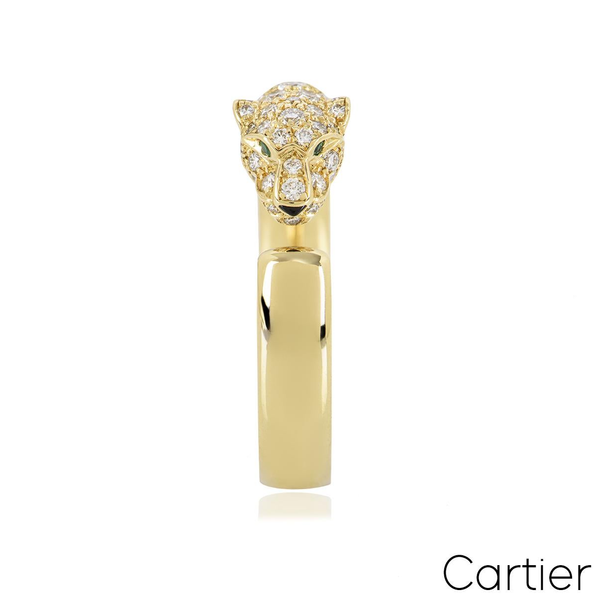 A striking 18k yellow gold ring by Cartier from the Panthere de Cartier collection. The ring features a panther motif pave set with 72 round brilliant cut diamonds totalling 0.68ct. The panther motif is further complemented with 2 round emeralds as