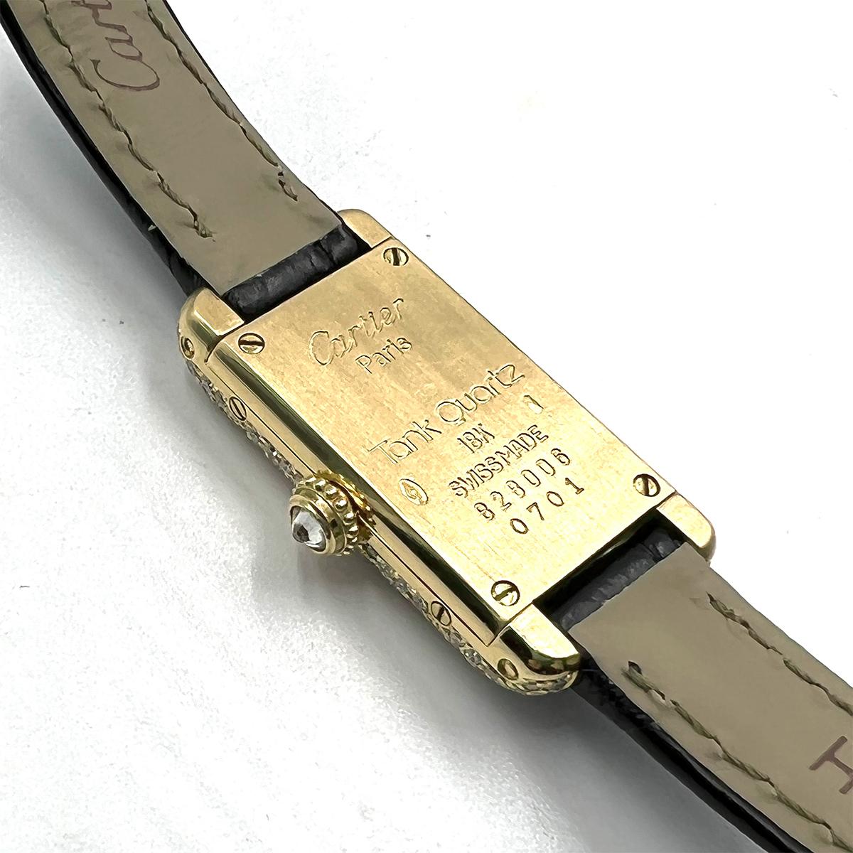 Vintage Cartier rare miniature dress wristwatch from the Tank Quartz collection, featuring a quartz movement; cream-toned dial with black painted Roman numeral hour markers & blued-steel dauphine-style hands; and, 14.4mm x 28mm 18k yellow gold case,