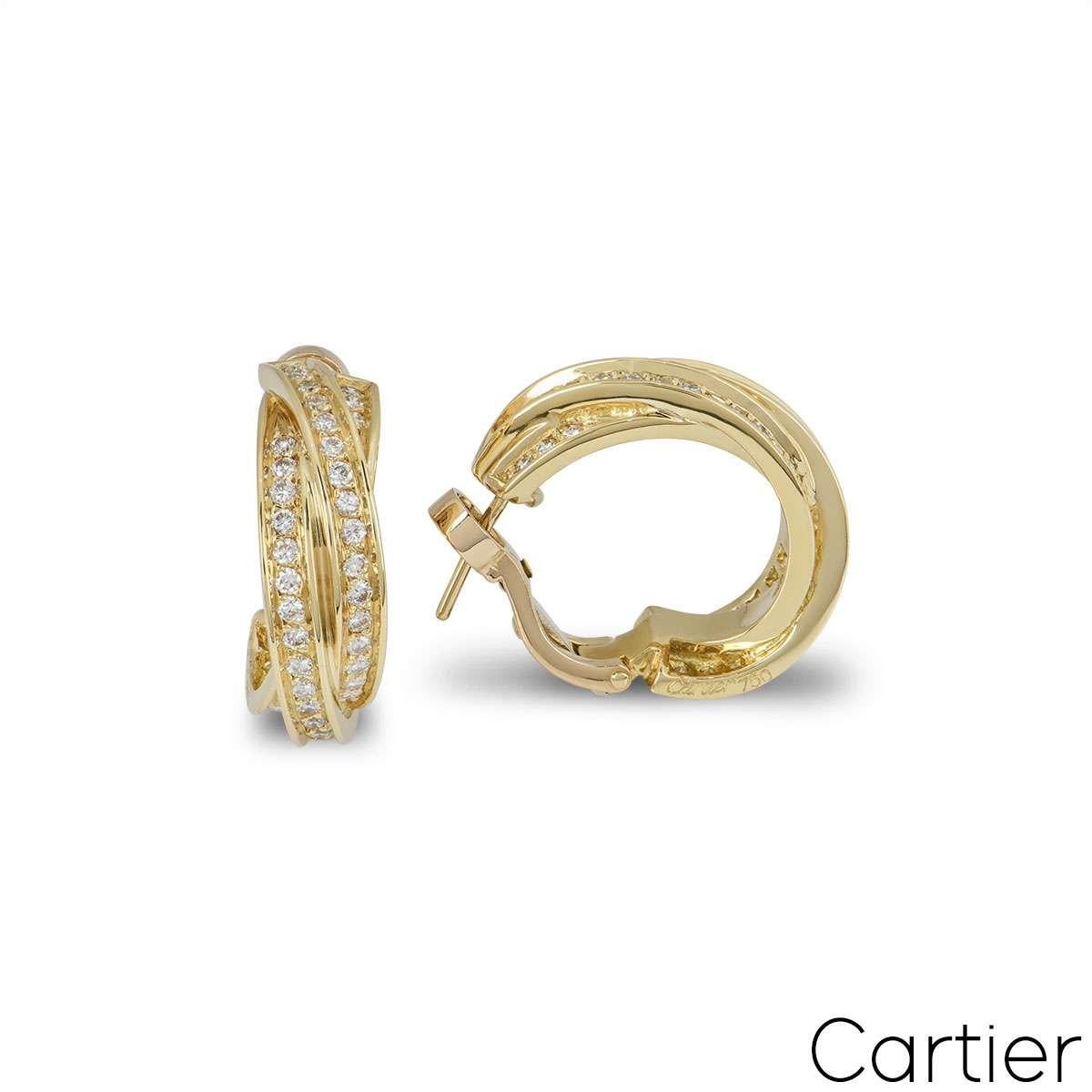 Paire de boucles d'oreilles en or jaune 18 cartier avec diamants de la collection Trinity de Cartier. Les boucles d'oreilles se composent de trois bandes d'or jaune entrelacées, serties de diamants ronds de taille brillant. Les diamants ont un poids