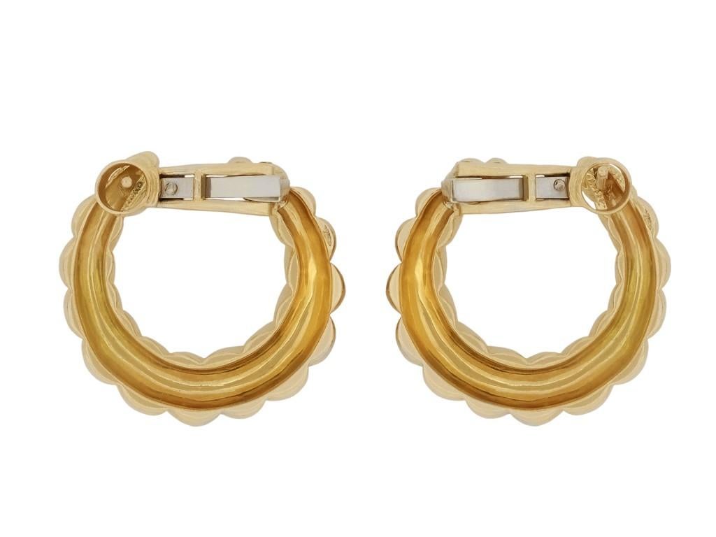 Cartier yellow gold earrings. A matching pair, each composed of a polished undulating hoop, fitted to reverse with a secure hinge clip and post, approximately 2.5cm in length. Marked 18 carat yellow gold, total approximate weight of 19.59 grams,