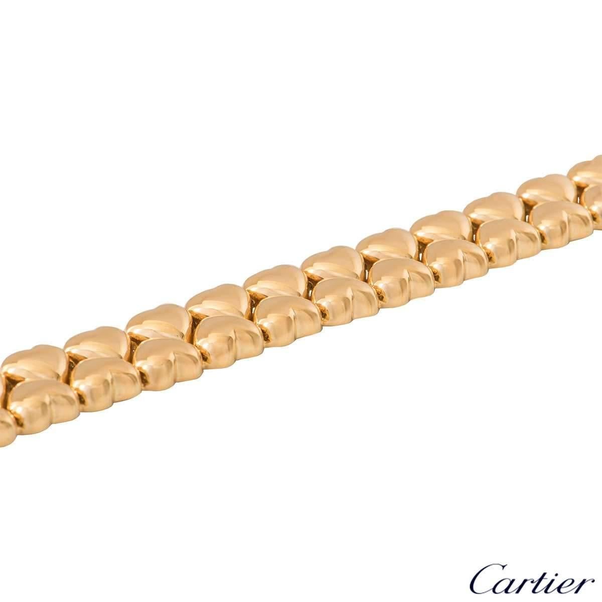 A Cartier 18k yellow gold heart link bracelet. The bracelet features 42 polished adjacently set heart link motifs. The bracelet measures 7 inches in length and 1.3cm in width with a gross weight of 41.95 grams.

The bracelet comes complete with a