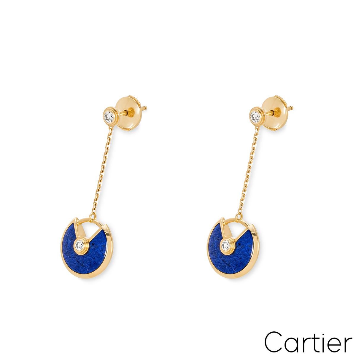 A pair of 18k yellow gold lapis lazulli and diamond earrings by Cartier from the Amulette de Cartier collection. The earrings are composed of a single round brilliant cut diamond, suspending a lapis lazuli talisman, with another round brilliant cut