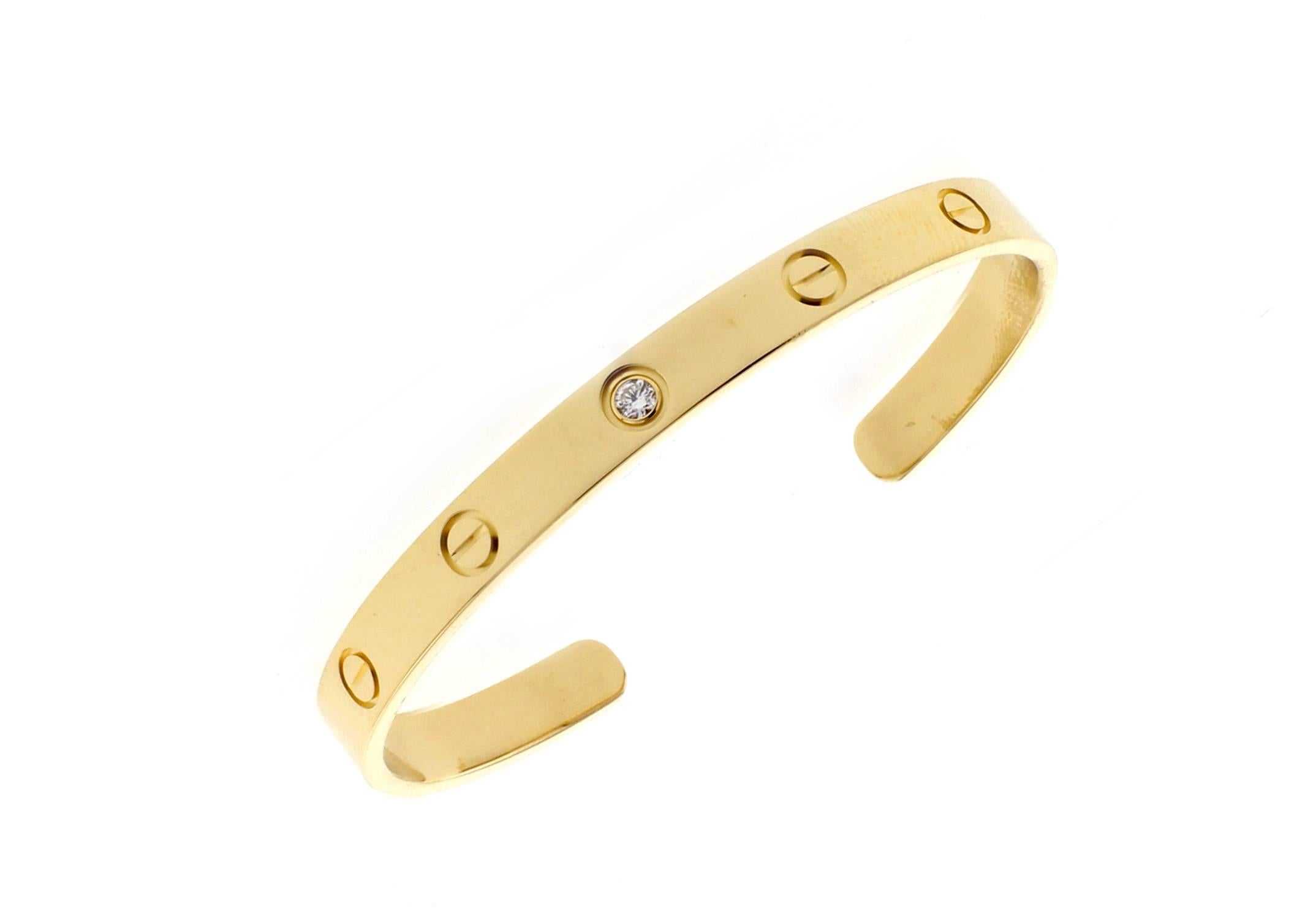 From Cartier, thier iconic love cuff. Fashioned from 18 karat gold with a single solitaire diamond. 16mm wide     Size 18   25.8grams