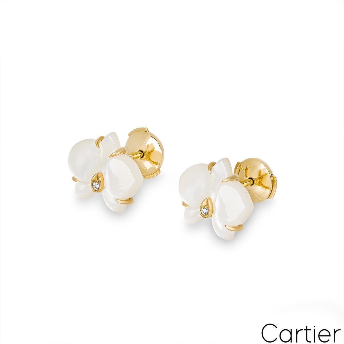A beautiful pair of 18k yellow gold mother of pearl and diamond earrings by Cartier from the Caresse d’Orchidées collection. The stud style earrings feature an orchid motif carved out of mother of pearl and adorned with a round brilliant cut diamond