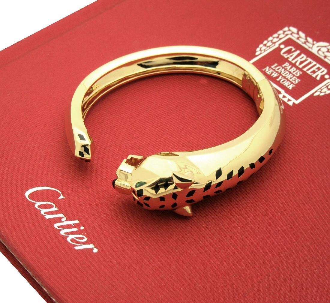 Cartier Bracelet en or jaune tête de panthère or jaune 18K 

Bracelet à charnière en or 18 carats de Cartier, représentant une tête de panthère sculptée avec des yeux en péridot, un nez en onyx et des taches en laque noire.

Cartier taille 18.