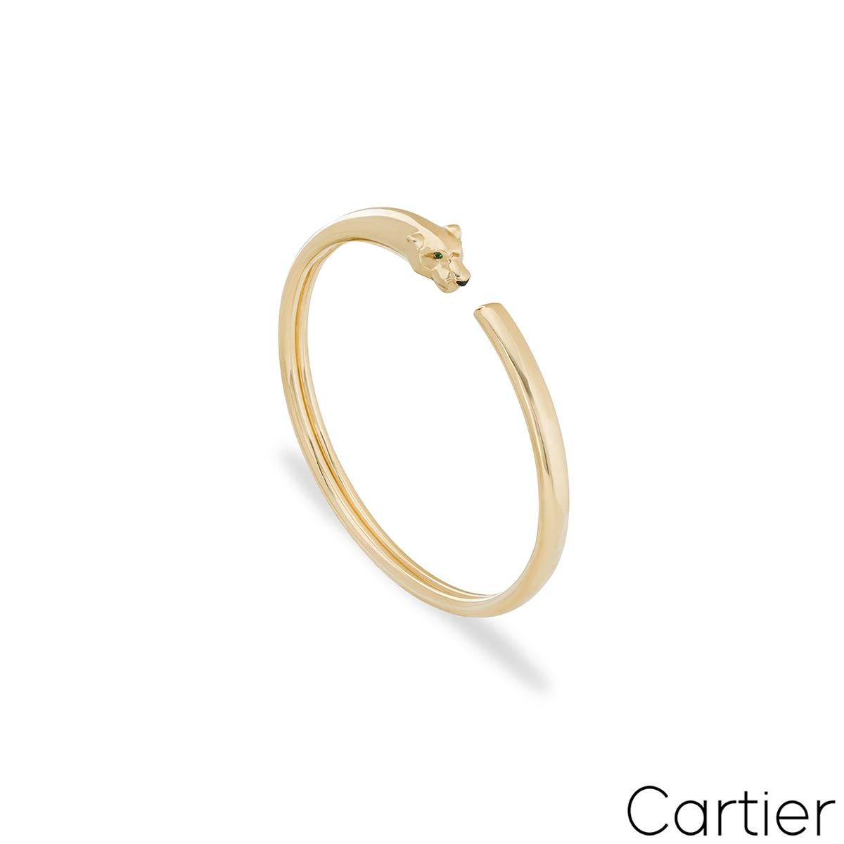 A striking 18k yellow gold bracelet by Cartier from the Panthere de Cartier collection. The bracelet comprises of a panther head motif set with 2 round tsavorites as eyes and an onyx nose. This bracelet is in unworn condition, it's a size 16 and has