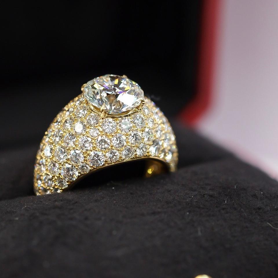 A Stunning 1980's Cartier Diamond Engagement Ring. This Gold and Diamond Ring is a beautiful Cartier piece. The ring has a center diamond of a 3.01 carats and pave round cut diamonds on the shank.
The Ring is a Signed and Numbered Cartier