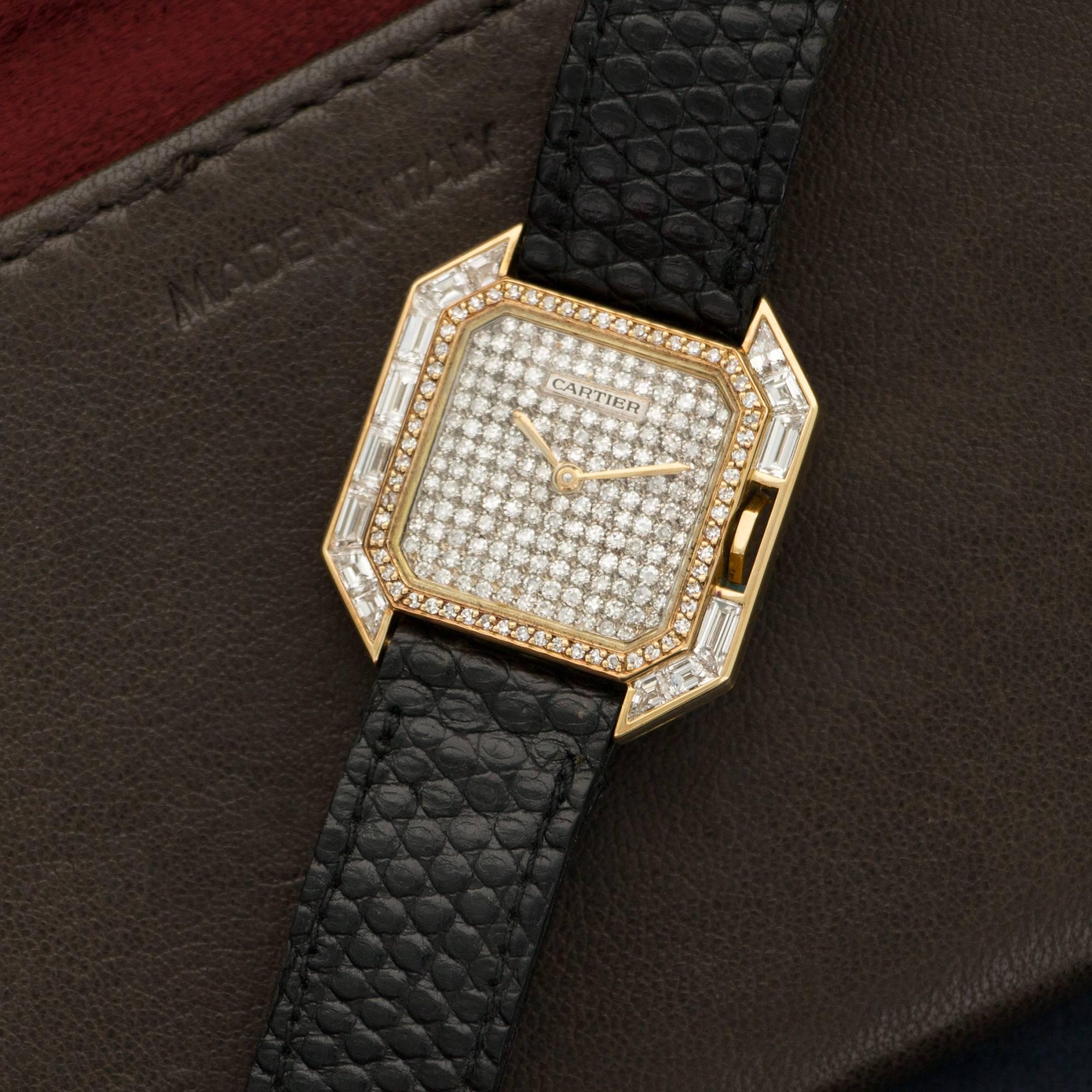 An 18k Yellow Gold Square Tank by Cartier. All Original Baguette Diamond Case with Pave Diamond Dial. Circa 1980's. Case Measures 25 X 25mm. Mechanical Wind. 