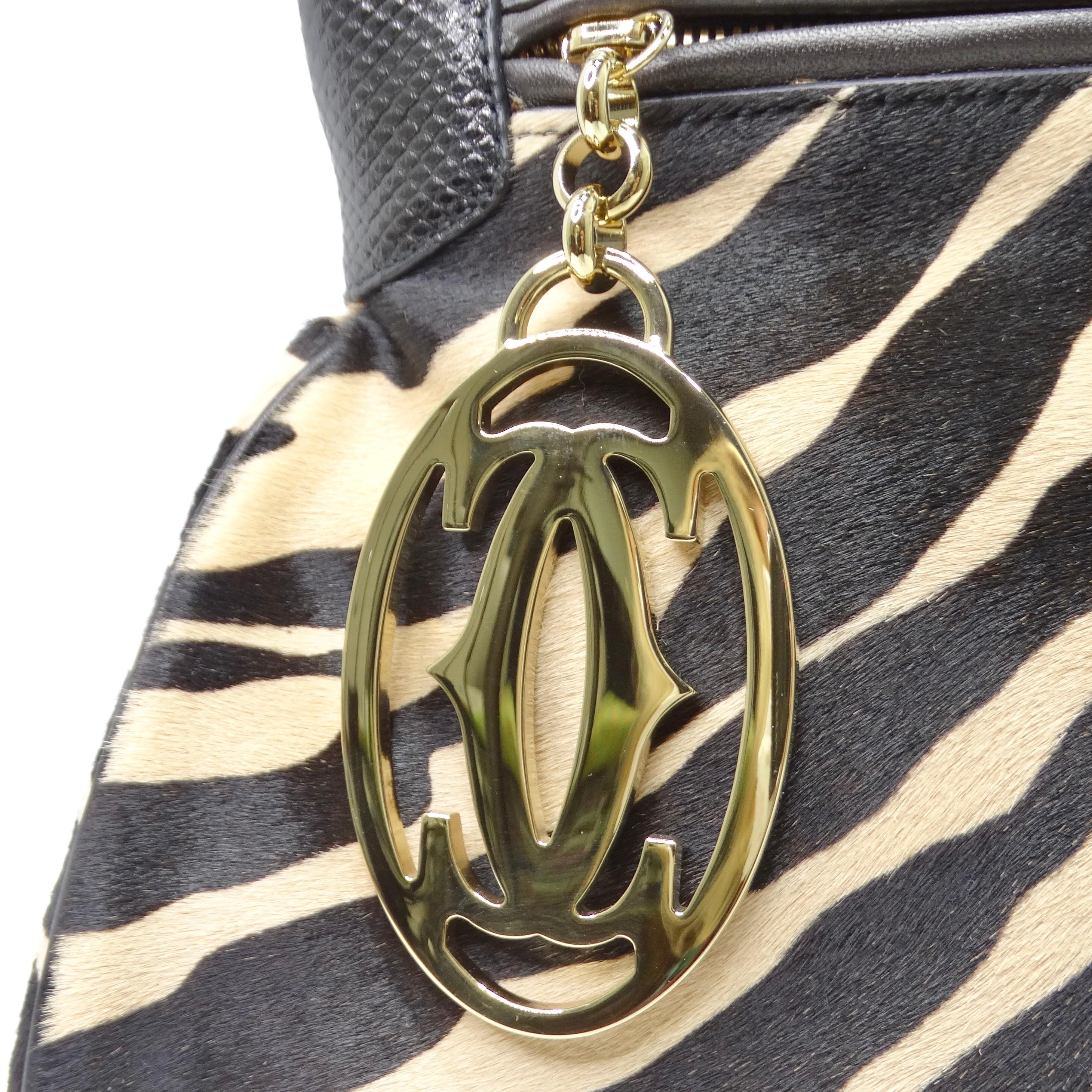 Introducing the Cartier Zebra Print Pony Hair 90s Shoulder Bag, a bold and luxurious accessory that exudes sophistication and style. Cartier's Marcello style shoulder bag features a striking zebra print pony hair exterior contrasted by black leather