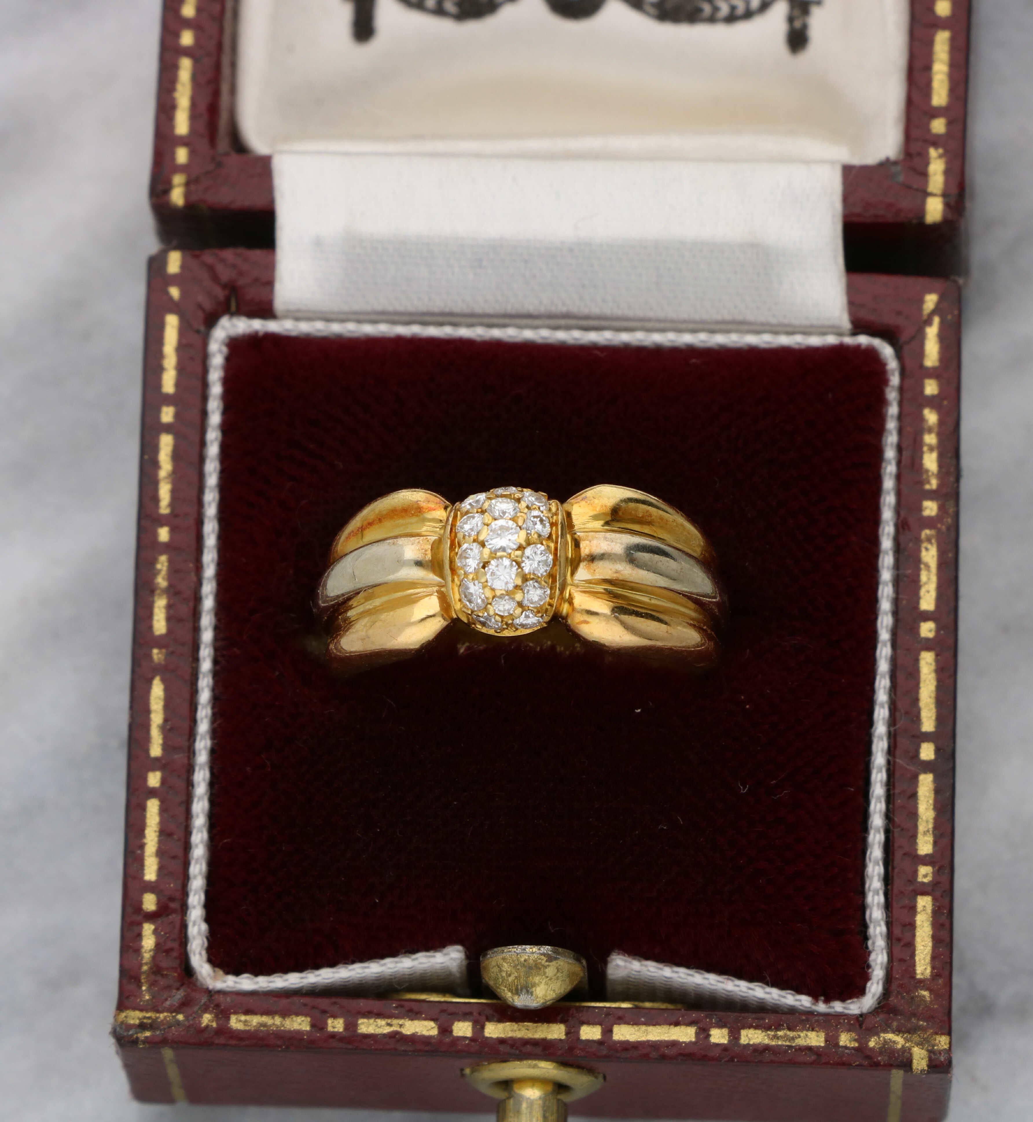 A lovely 18ct yellow and white gold diamond-set signed Cartier ring. The diamond-set centre measures 7mm and is set with estimated 0.20ct F/G VS. The band measures 8mm wide. and weighs 5.3 grams. This ring is a UK size L / US size 5 3/4. 

Diamond