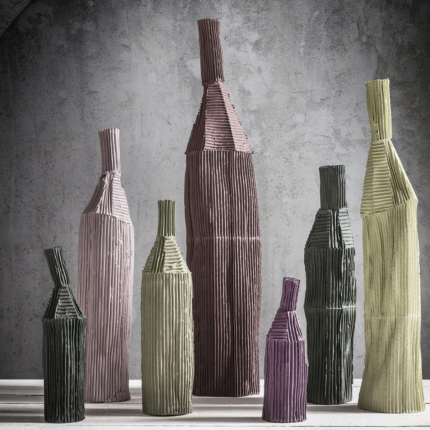 This elegant bottle is characterized by vertical and horizontal ridges that, when combined with the tall, cylindrical shape, convey a sense of balance that will give unique appeal to any décor. Part of the Cartocci Collection, this decorative object