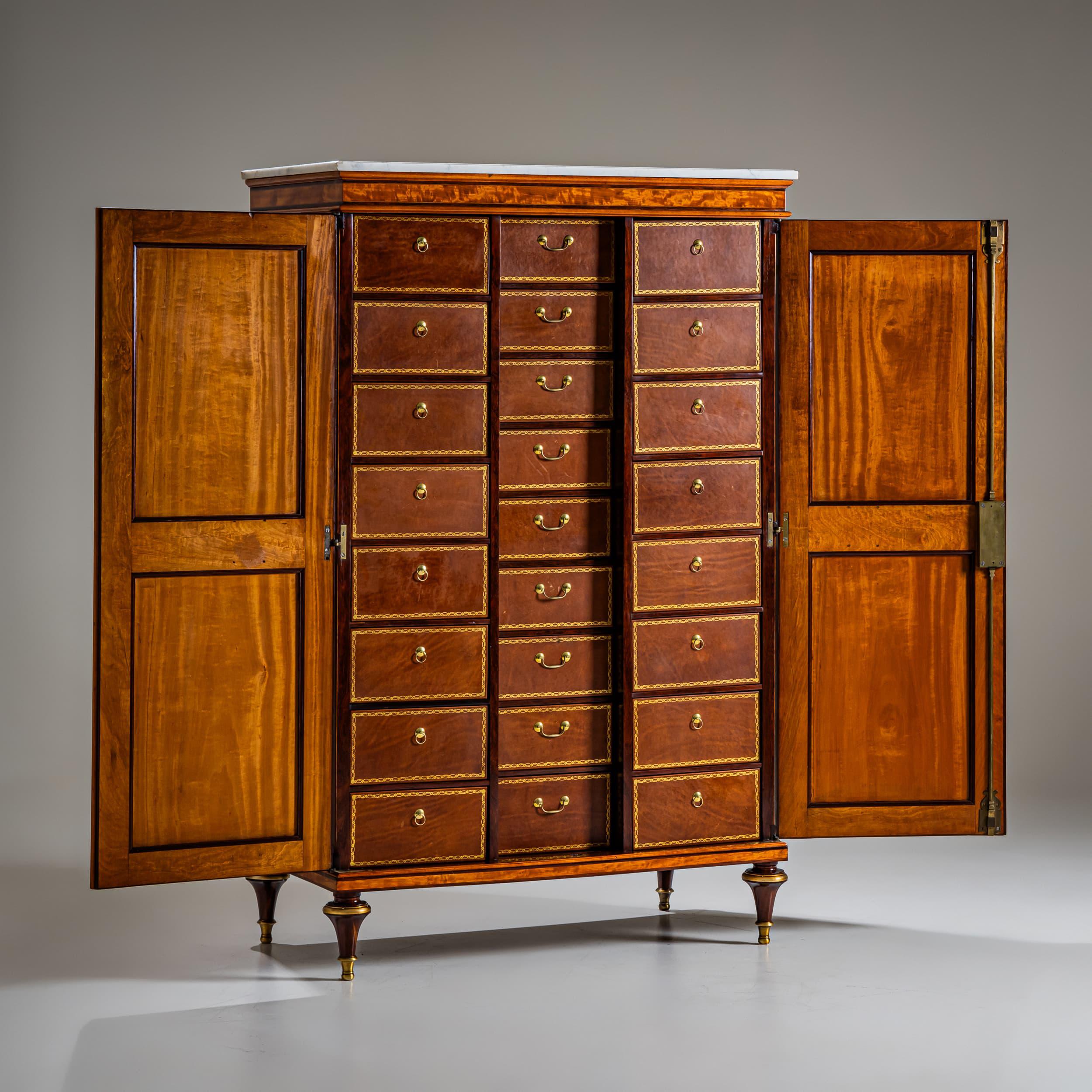 Armadio cartonnier raro e molto leggibile, realizzato intorno al 1780 in Francia e timbrato dal famoso ébéniste Claude Charles Saunier (1735-1807). Questo mobile a due ante in mogano poggia su gambe affusolate con sabot in bronzo dorato ed è