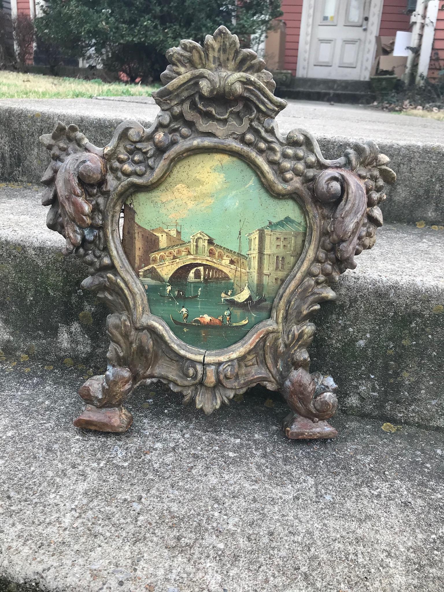 Scene depicting Grand Canal and Realto Bridge in a carved wood frame. 

Losses, wear, dirt and grime to the frame and throughout. Wear and yellowing to the canal scene. old signs of pest infestation. What is shown in photos is fairly complete. Out