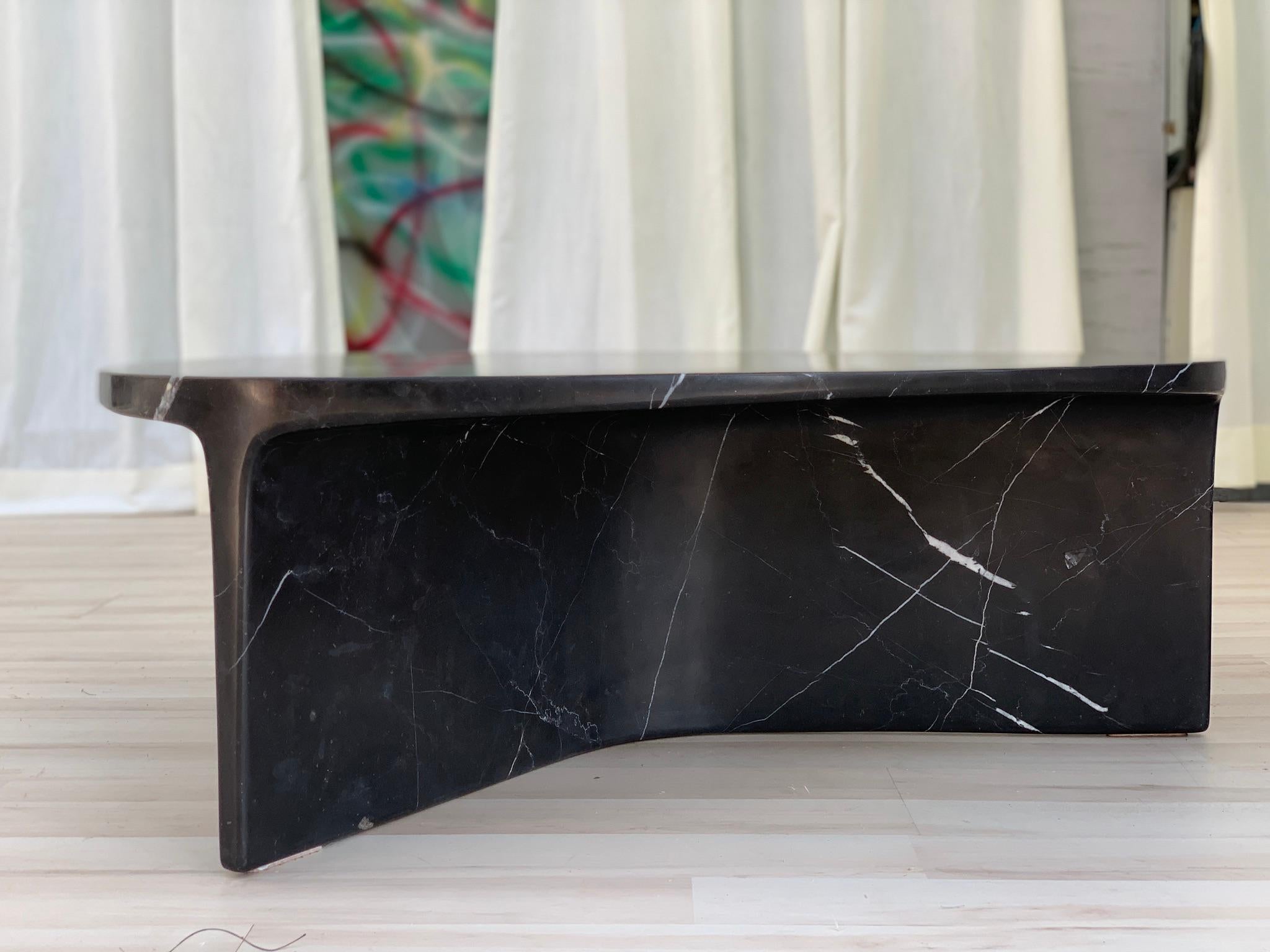 Der Carv Couchtisch wird aus einem einzigen Block aus schwarzem Nero Marquina-Marmor geschnitten.
Wesentliches und organisches Design, das auf natürliche Weise eine flache, fließende Tischplatte schafft
zu einem Y-förmigen Fuß, der die Adern des