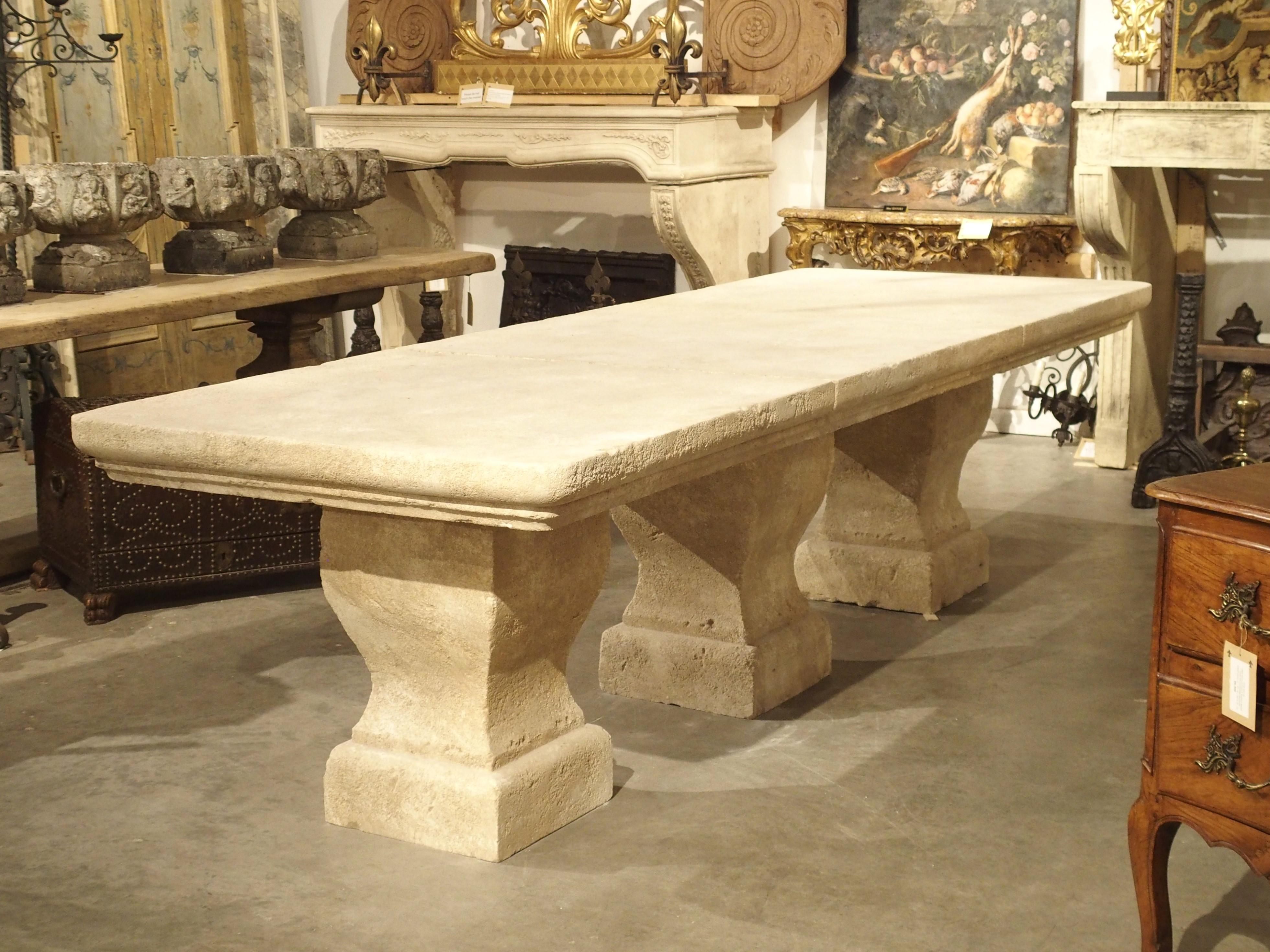 AA stunning and unique table, this carved Estaillade limestone dining table is from Provence, France. The massive top (roughly five inches thick!) has been made into three sections, each with two layers of cavetto molding. Each section is supported
