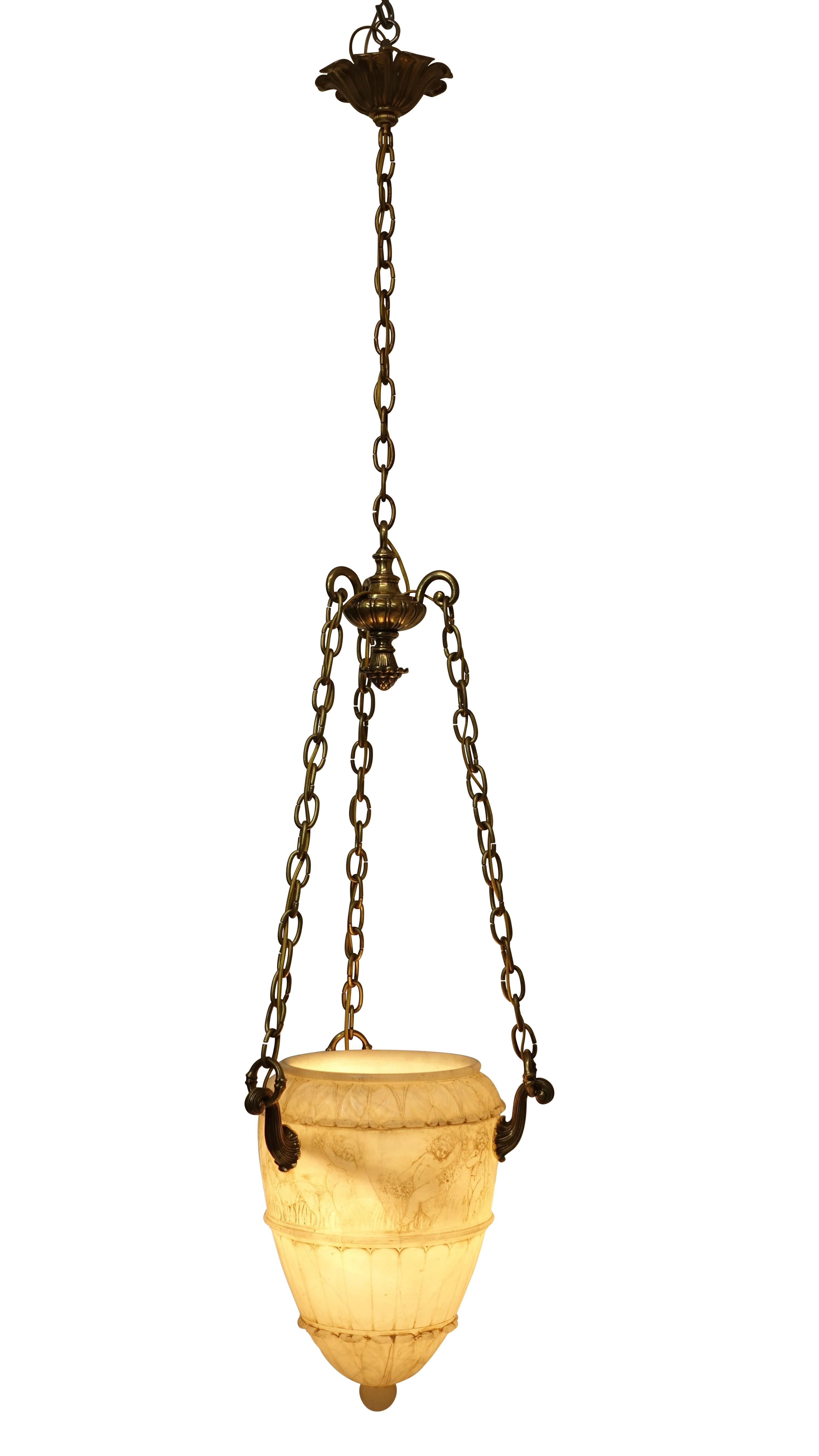 A unique alabaster drop pendant light fixture. Hand-carved with cherubs and goats below an egg and dart carved rim above a fluted body and ending with a knob finial. Having brass chain and canopy, length can be shortened if desired. Recently