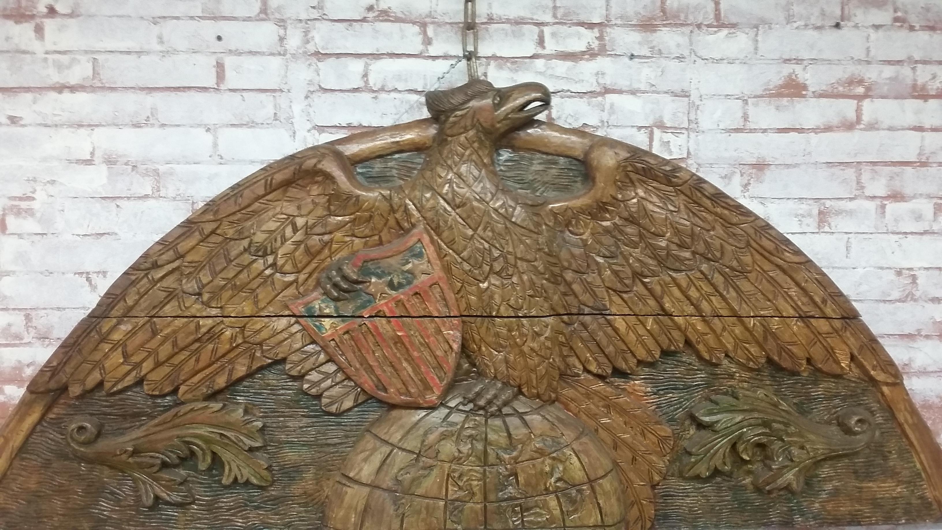 Vintage American eagle carved plague. Tremendous patriotic statement. This proud American eagle sits atop the world clutching an American stars and stripes shield. Originally from an estate in Westchester, NY.