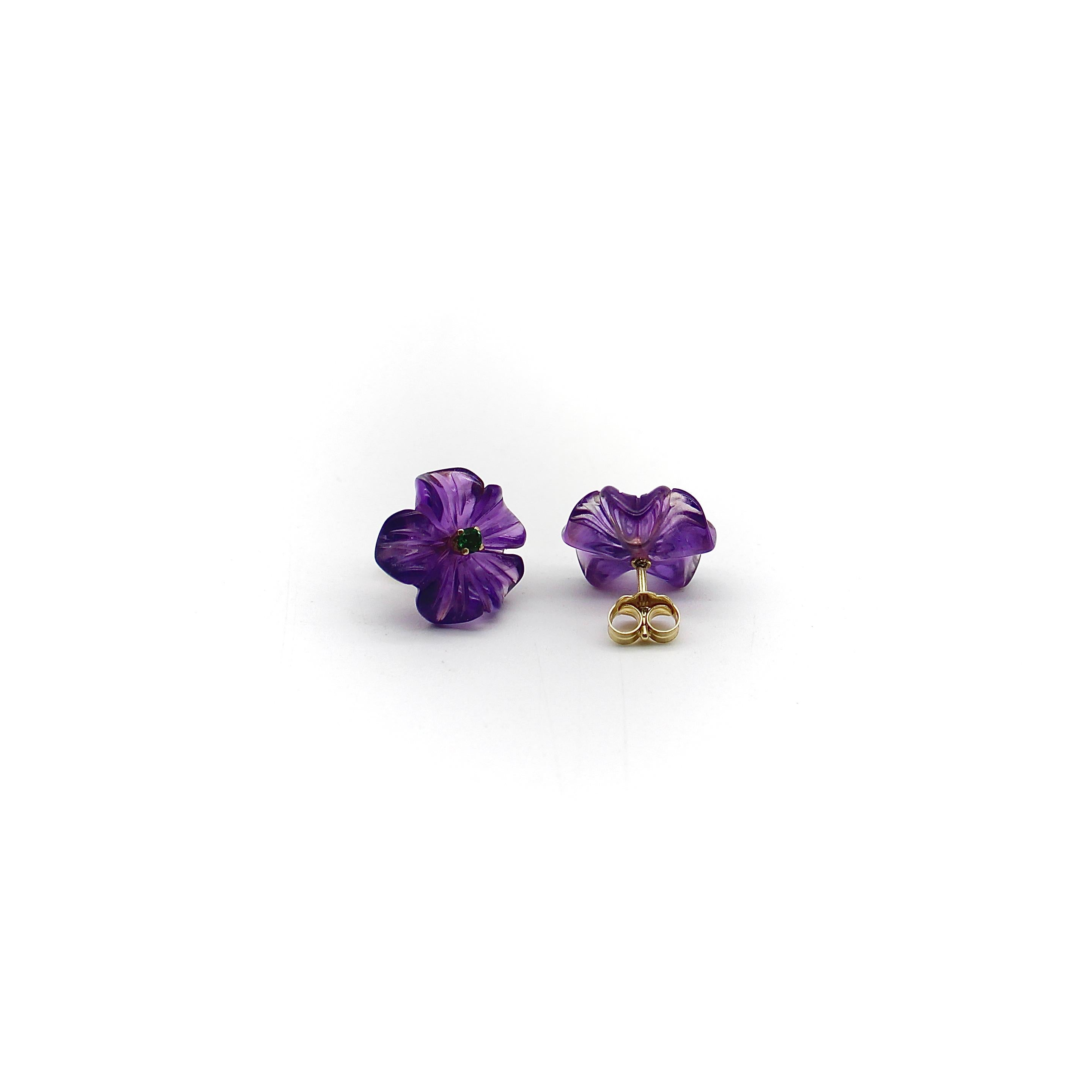 Diese Ohrstecker aus 14-karätigem Gold zeigen wunderschöne handgeschnitzte Amethyste in Form einer Blume. Die Blume hat fünf Blütenblätter, die sich von der Seite betrachtet wellenförmig bewegen und einen winzigen Tsavorit-Granat enthalten, der als