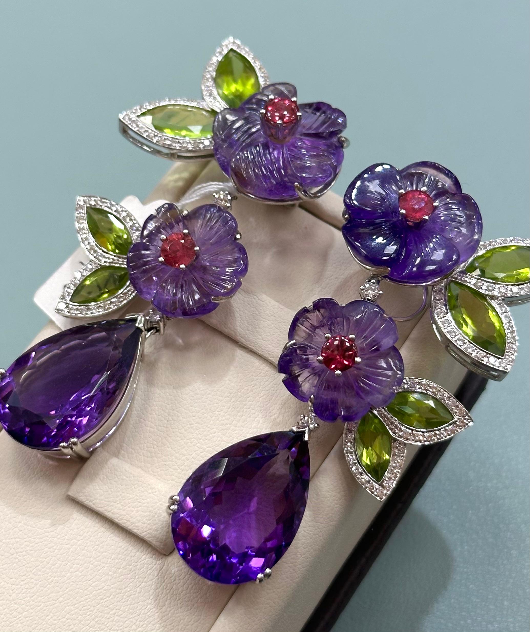 Carved Amethyst Peridot and Diamond Dangling Earrings with removal pear shaped amethyst from bottom of earrings in 18k white gold

Pear shaped amethyst around 15cts each. 

Total weight: 53.17 grams 