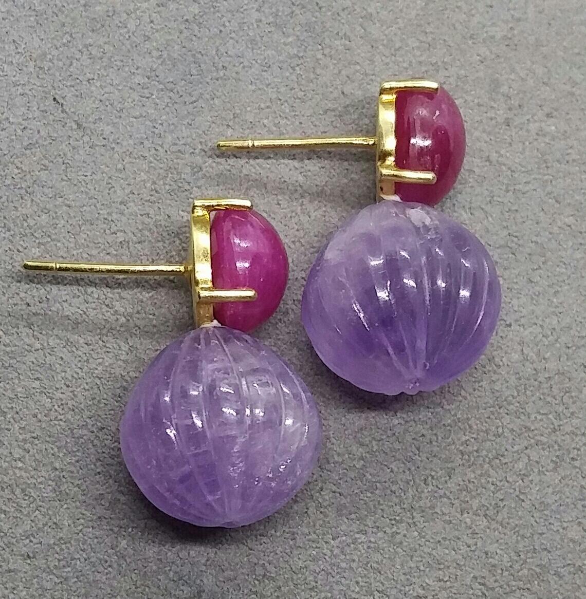 Simple chic stud earrings with a pair of ruby  oval cabochon size 10 x 11 mm set in 14 kt solid yellow gold on the top and 2 Natural Amethyst carved round drops of  16 mm in diameter

In 1978 our workshop started in Italy to make simple-chic Art