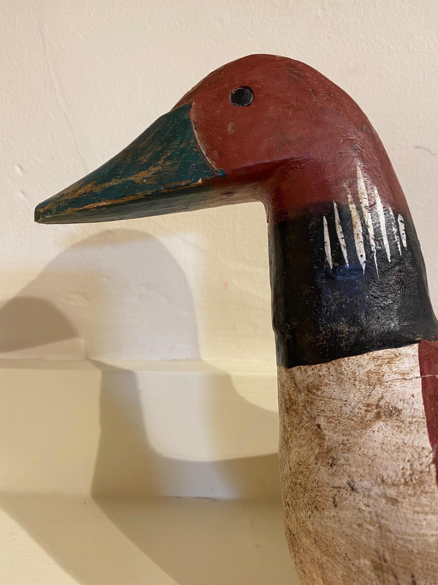 Vintage carved and decorated Native American Loon decoy, circa 1950. A hand carved pine decoy likely done with a hand ax (judging from the whittle marks), and painted in a bold pattern usually associated with Native American decoys. The red and