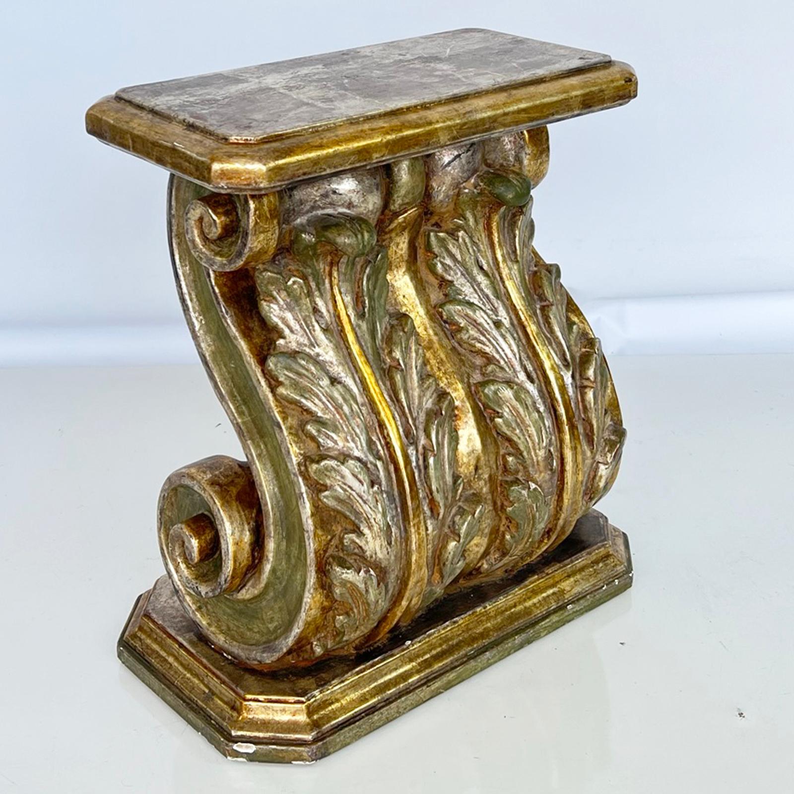 Neoclassical style side table, having a polychromed finish of silvergilt with gold and green glazing, over gessoed carved wood; its rectangular top on exaggerated S-scroll, corbel base, carved with acanthus leaves, on a conforming, graduated plinth