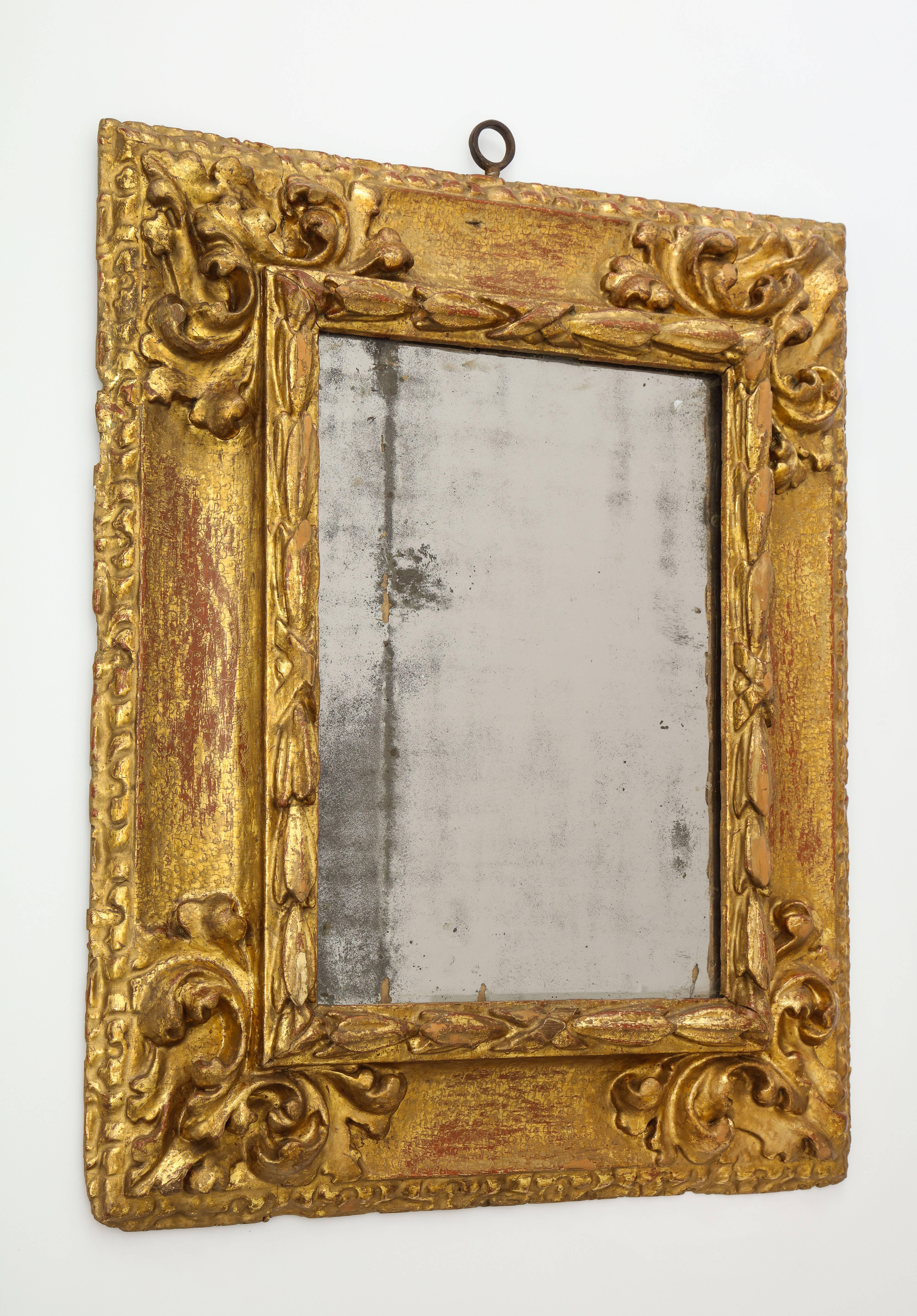 An exceptional carved and gilded reverse profile Spanish Baroque mirror frame; the cove molding decorated with scale shaped punch work. 
Southern Spain, circa 1650-1700 

A reverse profile Spanish frame (meaning that the window opening is