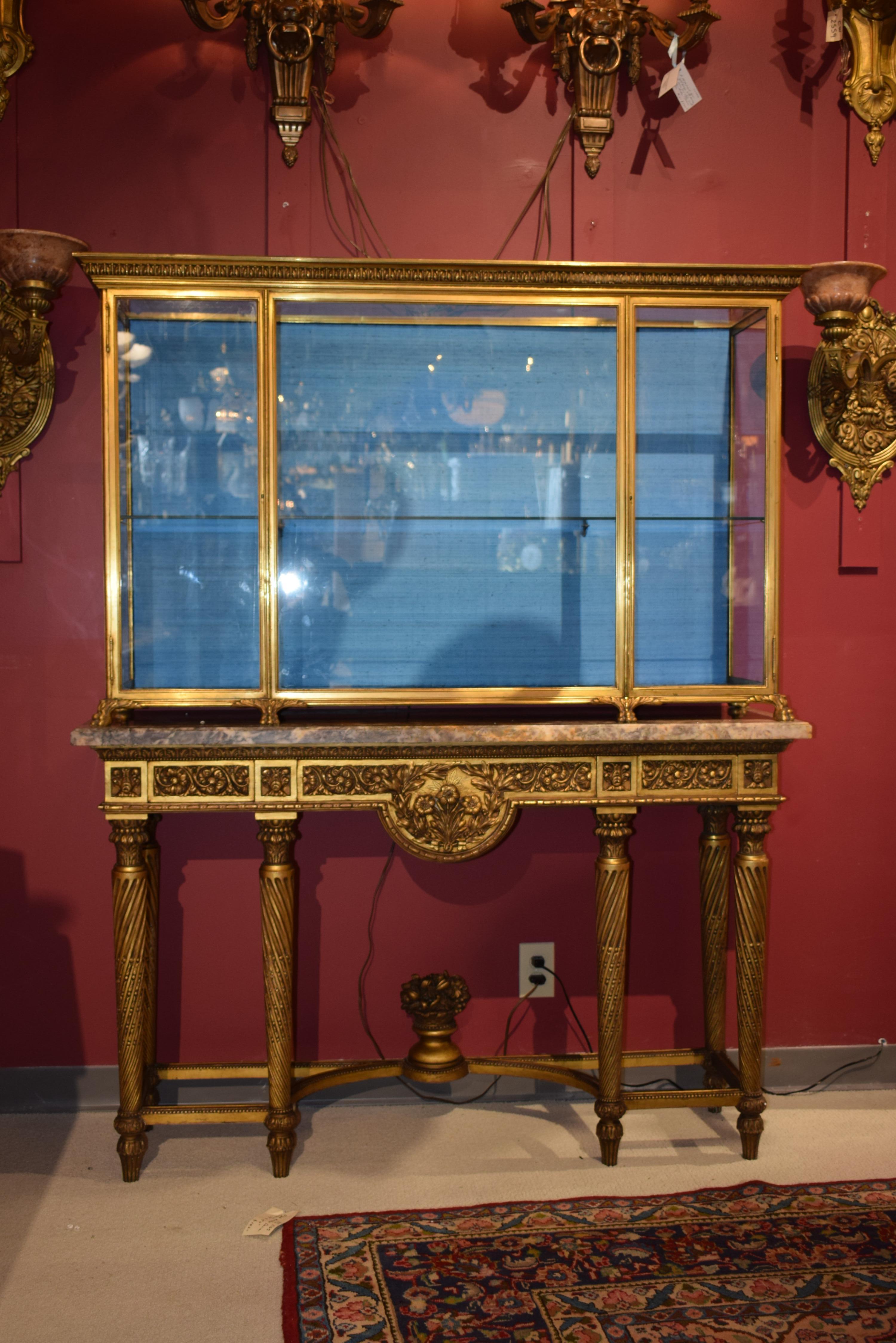 A fine carved & gilt wooden console, marble top together with an exceptional gilt bronze display cabinet (one glass shelf inside). France, circa 1880. 
Console: Height 35
