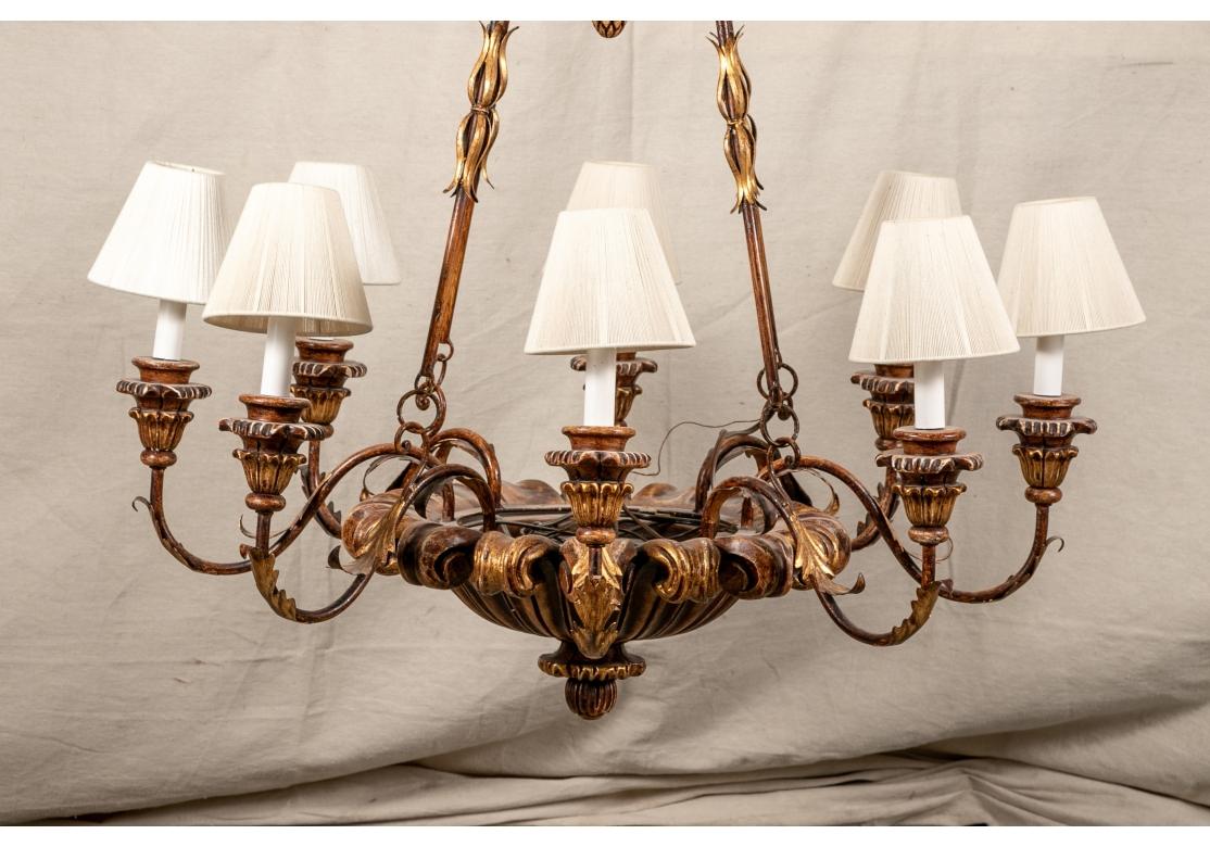 An 8 light chandelier in the 19th c. style. With a foliate scrolled bowl as the base for the 8 lights on scrolled arms with gilt tole acanthus leaves and carved sockets. Four bars suspend the chandelier from the carved and gilt urn form top. With a