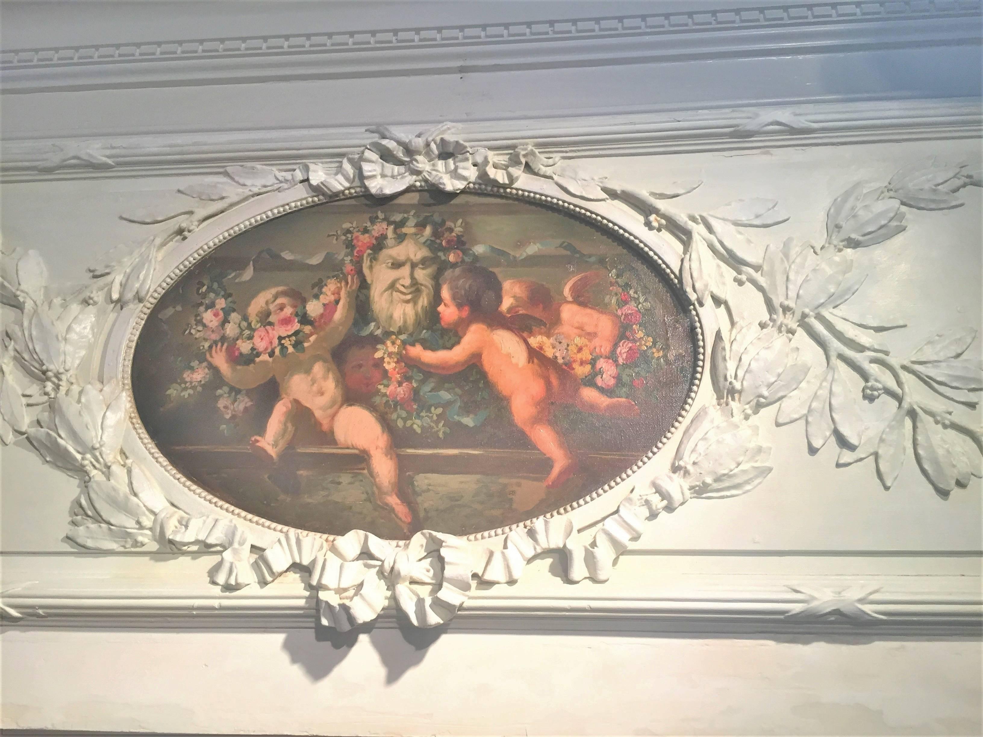 The architectural frieze fragment removed from panelling. The neoclassical styled panel with leaf garland intertwined with ribbon surrounding a colorful oil inset of four cherubs or putti dancing merrily with ribbon and floral garlands, probably an