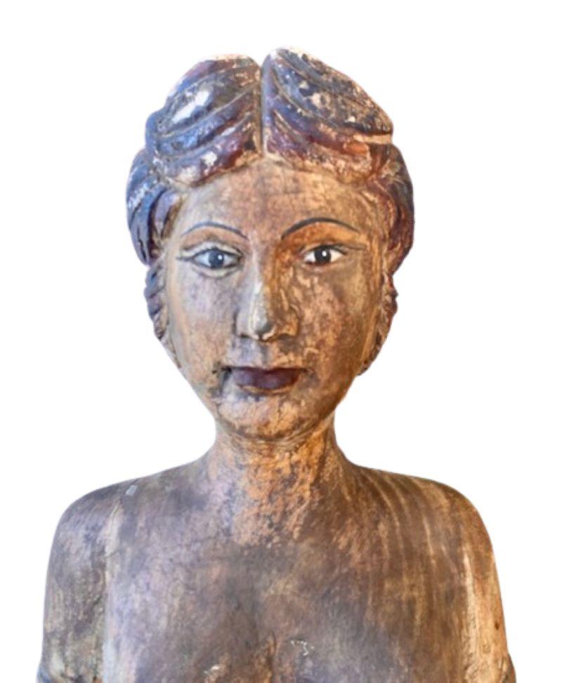 Early Vintage Folk Art Carved and Painted Bust from French Indonesia, early to mid 20th Century, a hand carved and polychromed bust from French Indonesia, depicting a Rani with plaited hair, delicate make-up and a sea-foam green sari, mounted on a